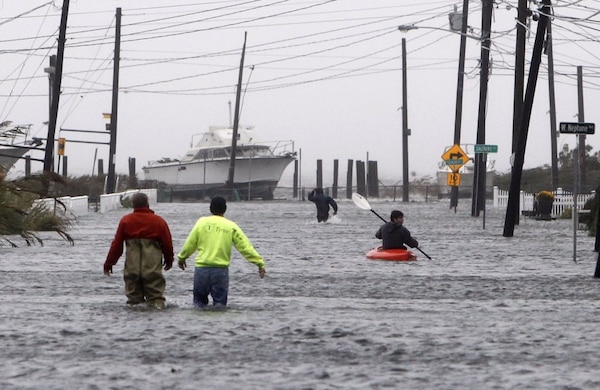 People wade and paddle down a flooded street as Hurricane Sandy approaches, Oct. 29, in Lindenhurst, N.Y. Gaining speed and power through the day, the storm knocked out electricity to more than 1 million people and figured to upend life for tens of millions more.