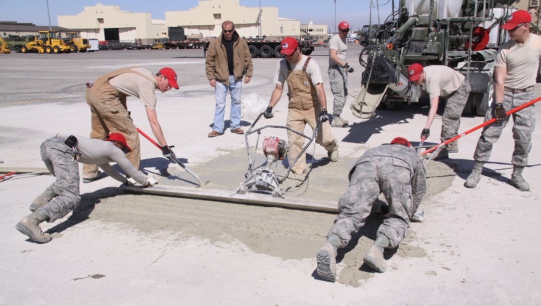 After the U.S. Army Engineer Research and Development Center Airfield Damage Repair (ADR) team train the airmen, members of the Rapid Engineer Deployable, Heavy Operational Repair Squadron Engineer (RED HORSE) squadron practice screeding skills using the materials, equipment and methods to repair craters in preparation for a cold weather demonstration at Malmstrom Air Force Base, Mont