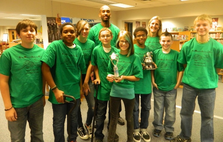 Students from Walt Whitman Middle School and their coaches show their first place trophy won during their first competition in the FIRST LEGO® League tournament.