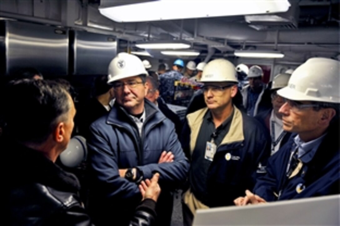 Deputy Defense Secretary Ashton B. Carter, center, listens while touring the aircraft carrier USS Theodore Roosevelt in Norfolk, Va., Jan. 17, 2013.