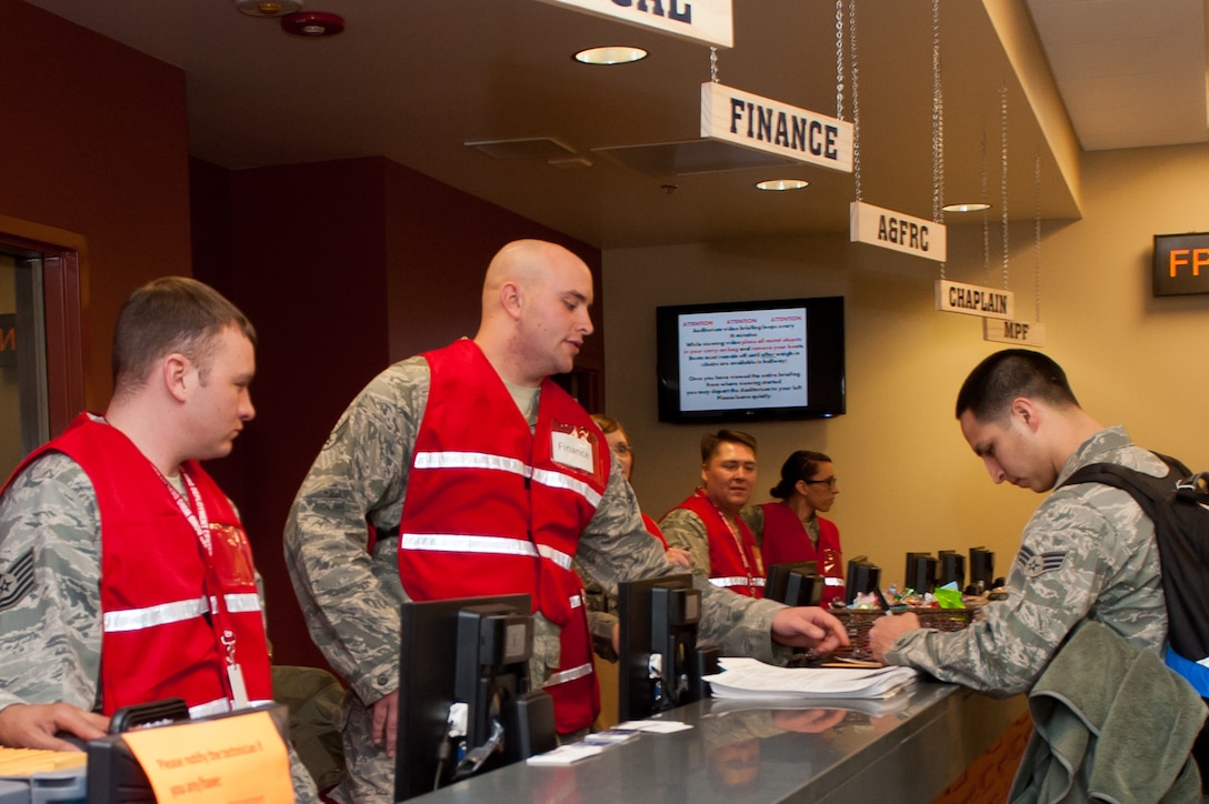Airmen assigned to personnel deployment function assist deploying Airmen at the Deployment Center on Ellsworth Air Force Base, S.D., Jan. 19, 2013. Ellsworth has a variety of programs in place to support Airmen who deploy. (U.S. Air Force photo by Airman 1st Class Kate Thornton-Maurer/ Released)
  
