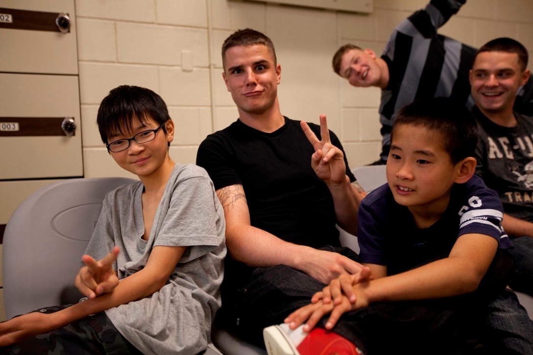 Lance Cpl. Cody J. Turner, a combat engineer with Combat Logistics Battalion 31, 31st Marine Expeditionary Unit, and a native of Secretary, Md., poses with children from the Nagomi Nursing Home for Children here Jan 12. The children’s home, a privately-owned organization, brought 65 kids ranging from the ages of four to 18 to the base for a day of bowling and fun. The 31st MEU is the only continuously forward-deployed MEU and is the Marine Corps’ force in readiness in the Asia-Pacific region.