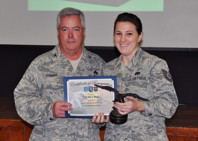 Tech. Sgt. Mary Mayo, 919th Maintenance Operations Flight, receives her award as 2012 NCO Support Professional of the Year from Col. Kenneth Honaker, 919th Maintenance Group commander. (U.S. Air Force photo/Dan Neely)