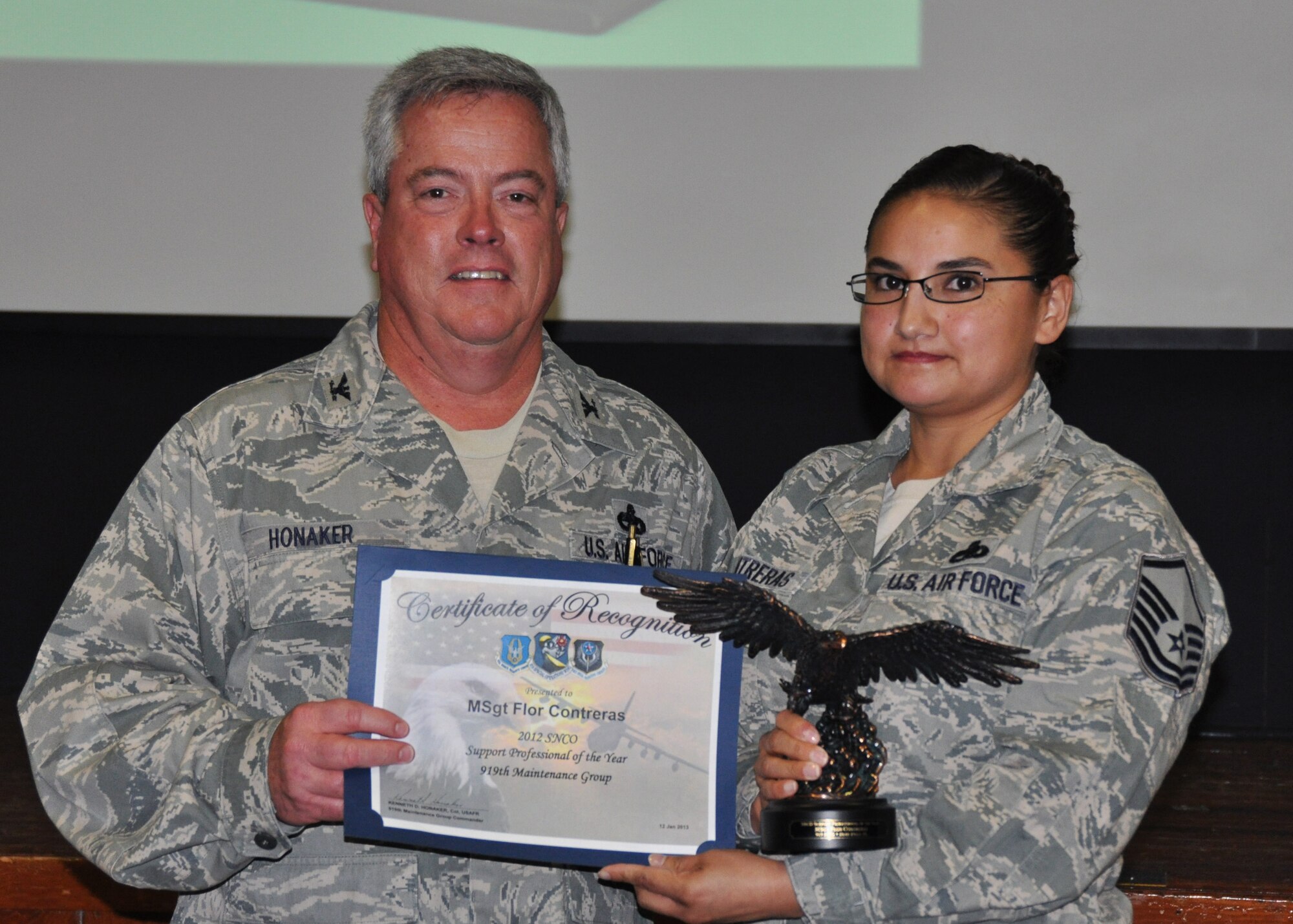 Master Sgt. Flor Contreras, 919th Maintenance Operations Flight, receives her award as 2012 Senior NCO Support Professional of the Year from Col. Kenneth Honaker, 919th Maintenance Group commander. (U.S. Air Force photo/Dan Neely)
