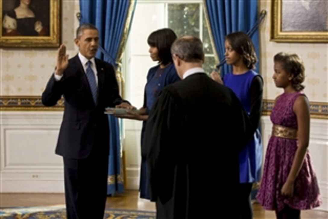 Supreme Court Chief Justice John Roberts administers the oath of office to President Barack Obama during the official swearing-in ceremony in the Blue Room of the White House on Inauguration Day, Sunday, Jan. 20, 2013. First Lady Michelle Obama, holding the Robinson family Bible, along with daughters Malia and Sasha, stand with the President.