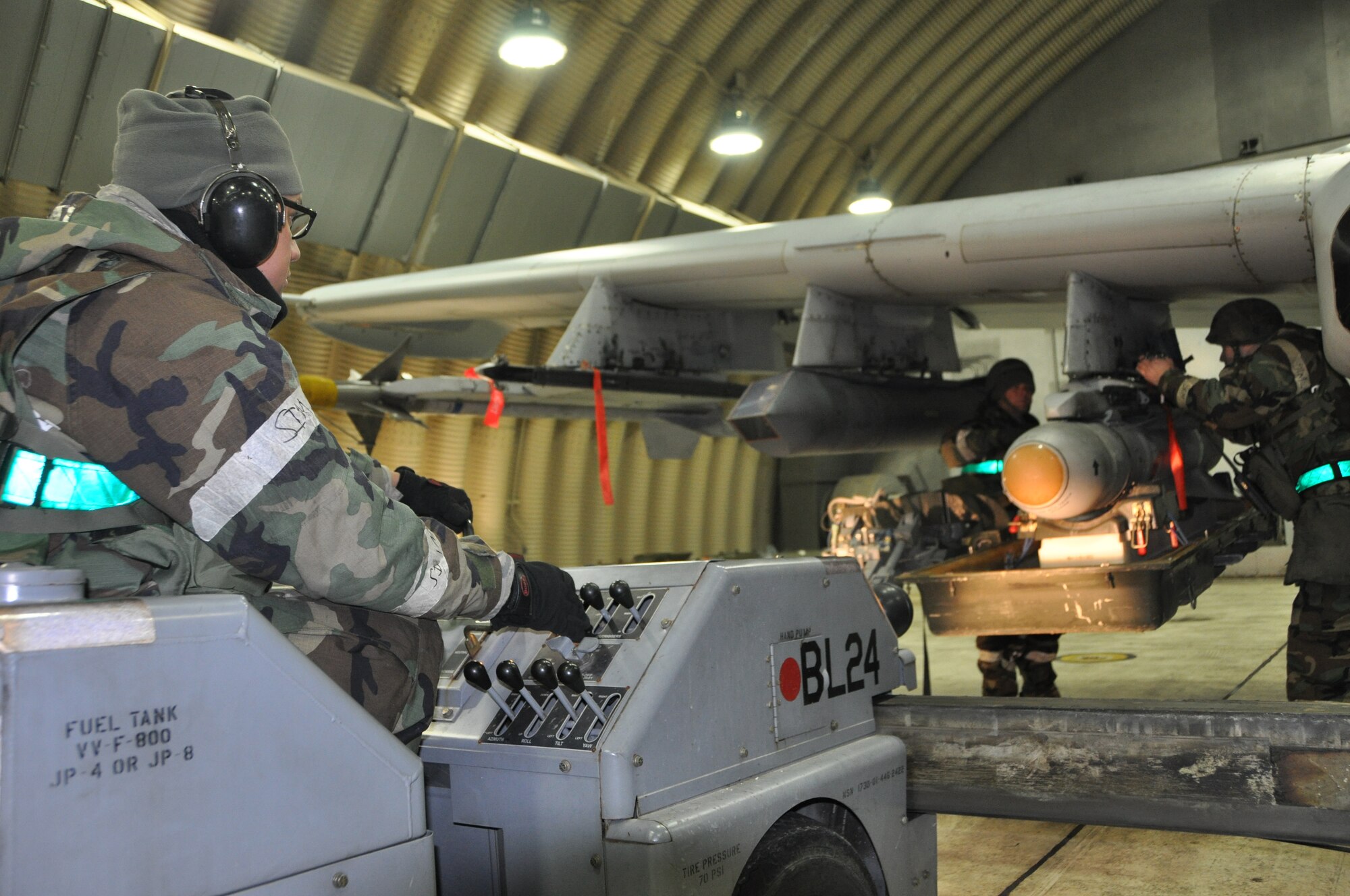 Staff Sgt. Michael Palmisano (right), Senior Airmen Jeffery Olmeda (far left) and Adam Hinojosa (center), 51st Aircraft Maintenance Squadron aircraft armament weapons systems specialists, load munitions onto an aircraft during operational readiness exercise Beverly Midnight 13-01, Jan. 17, 2012. The exercise tests Osan Airmen’s abilities to perform in heightened states of readiness. 