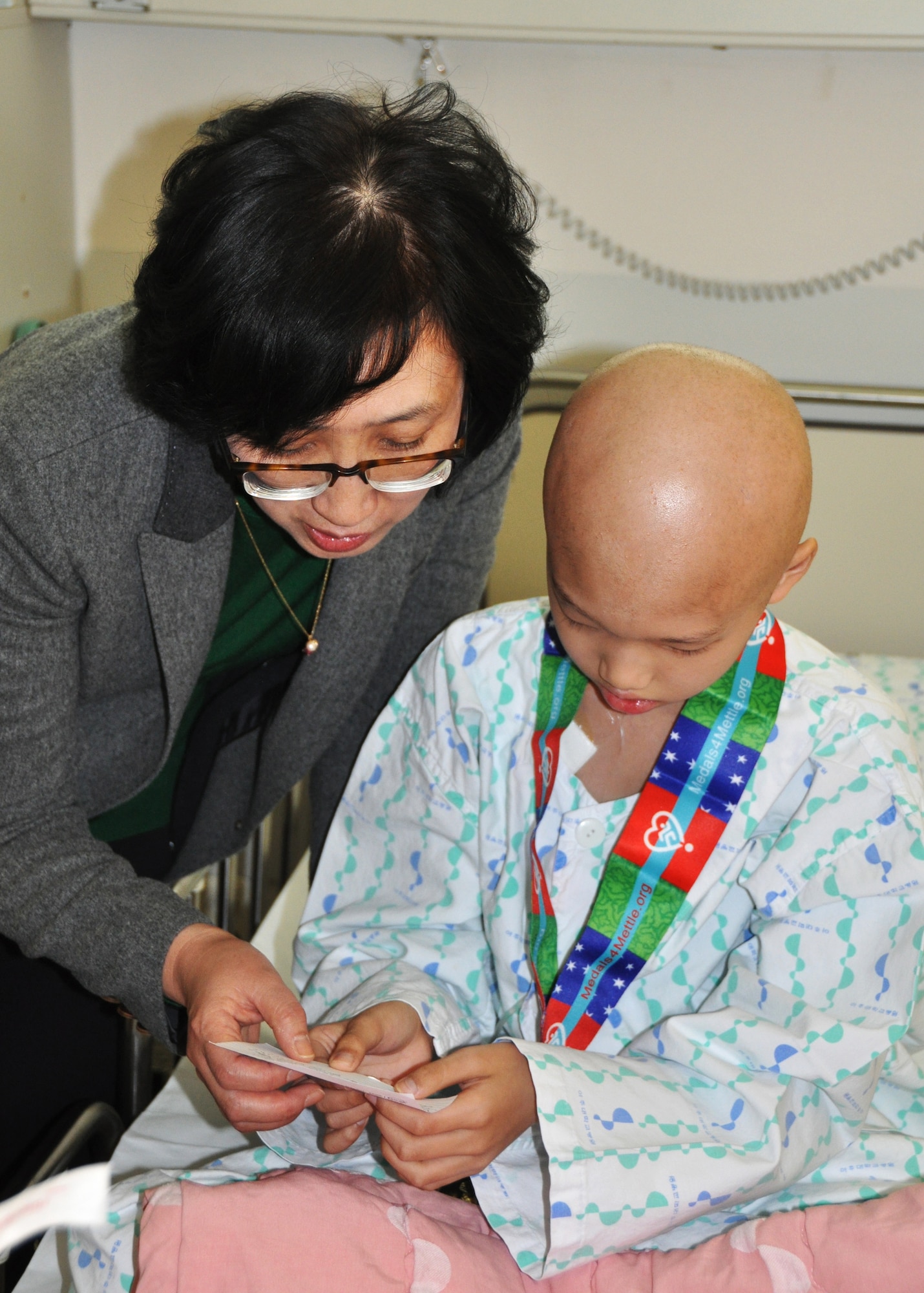 Chun Mison, Ajou University Hospital head of radiation at the Cancer Center, translates the story about the victor who provided the medal presented to a patient Jan. 12, 2013 with the Medals for Mettle program. The medals were donated by active-duty members and dependants from Osan Air Base. (U.S. Air Force photo/Senior Airman Kristina Overton)