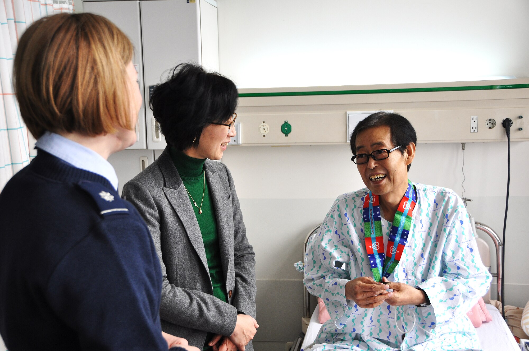 A patient at Ajou University Hospital expresses his appreciation after being presented a medal from Lt. Col. Rhonda Larson, 7th Air Force director of manpower, personnel and services, Jan. 12, 2013. Volunteers from Osan Air Base traveled to the hospital in Suwon and gave out 16 medals attached with stories from the victors to patients for their mettle and courage in facing personal health challenges. (U.S. Air Force photo/Senior Airman Kristina Overton)