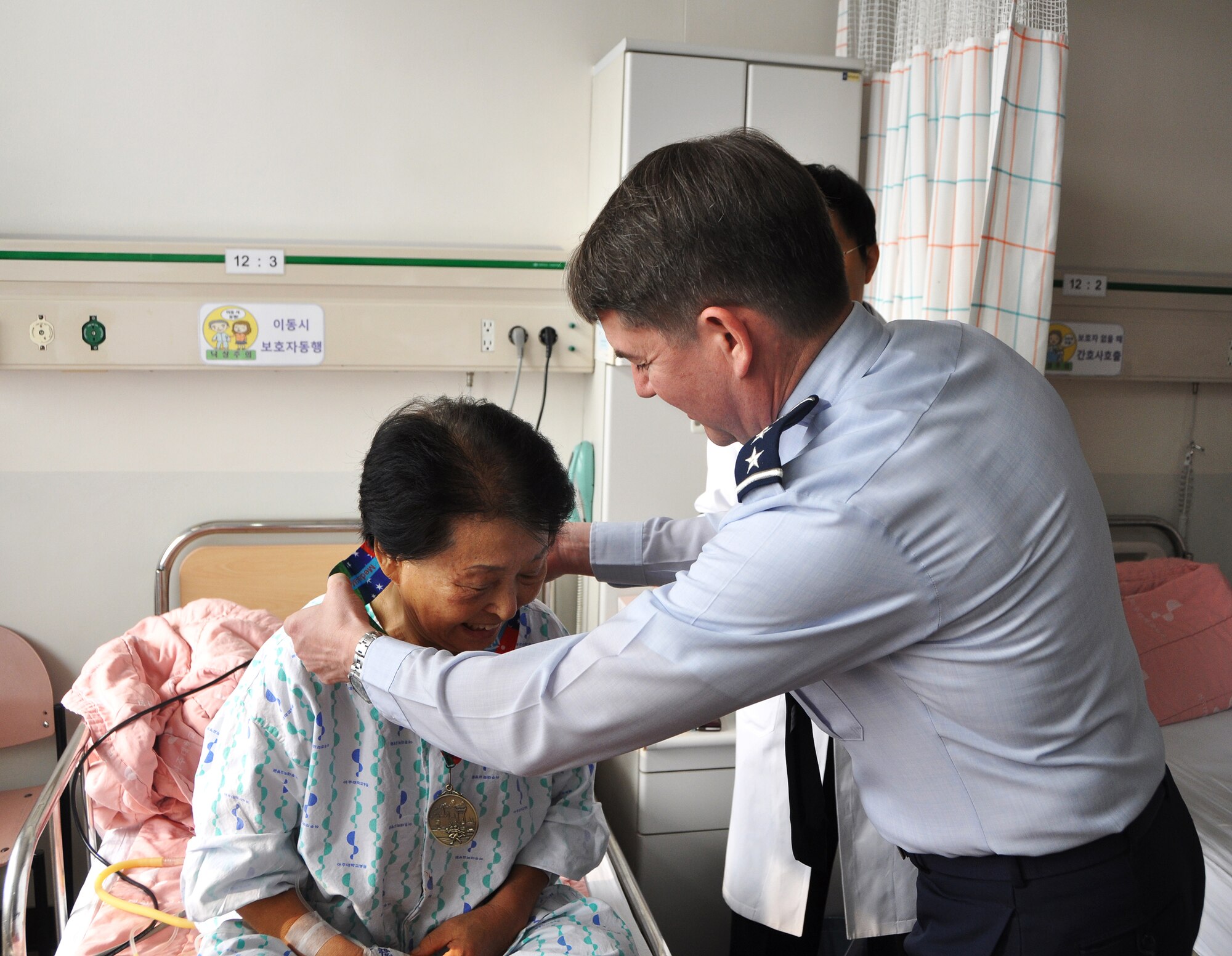 Lt. Gen. Jan-Marc Jouas, 7th Air Force commander, presents the first medal of the day to a patient at the Ajou University Hospital in Suwon, Republic of Korea, Jan. 12, 2013 for the Medals4Mettle program. The Medals4Mettle program provides hope and encouragement by donating hard-earned finisher’s medals to patients fighting debilitating illnesses or injuries. (U.S. Air Force photo/Senior Airman Kristina Overton)
