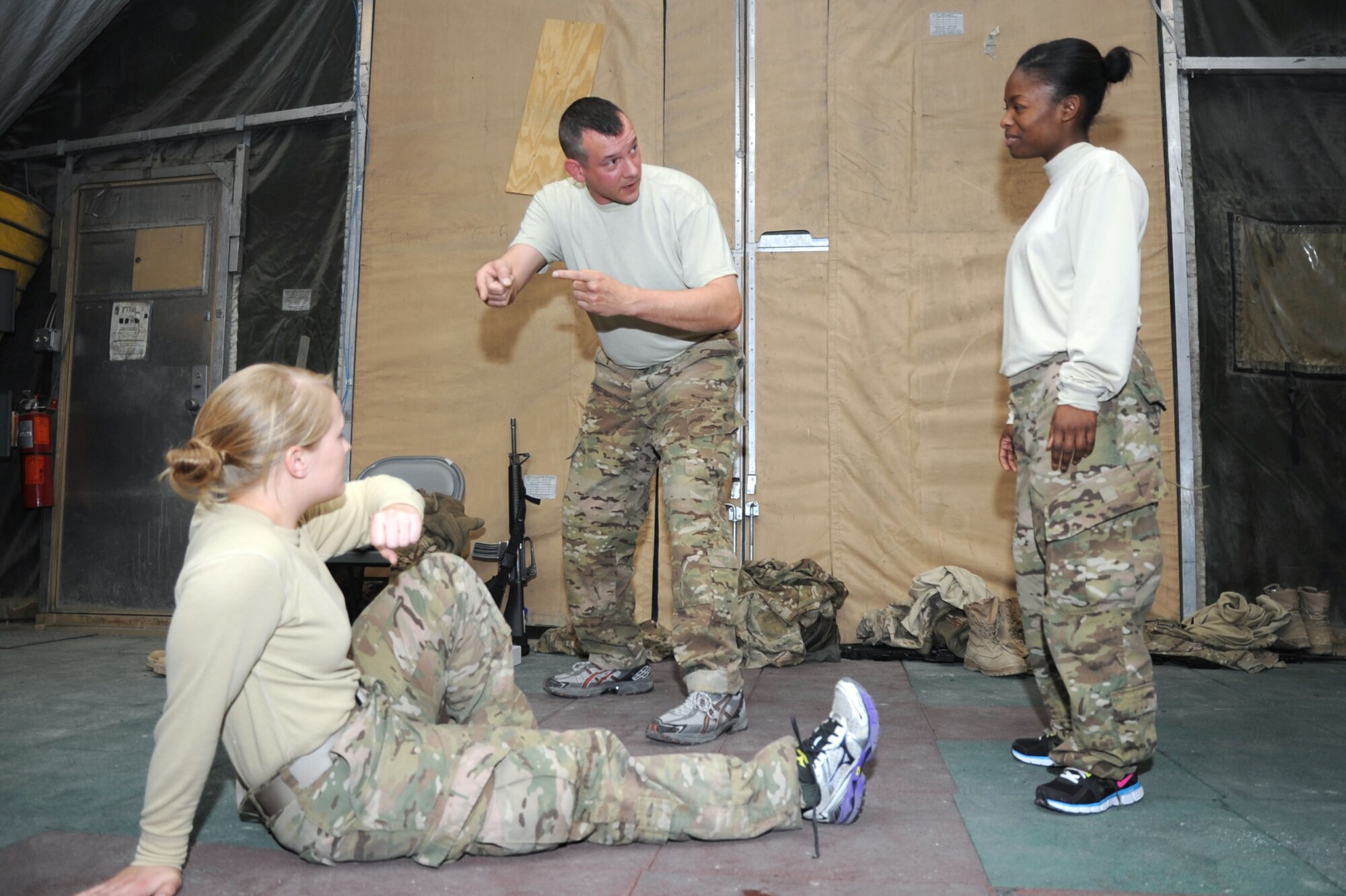 Capt. Randall Claar, 455th Expeditionary Operations Support Squadron weather flight commander, instructs Airmen 1st Class Megan Wendland (left) and Emilia Mason, 4th Expeditionary Reconnaissance Squadron aviation resource managers, on proper deflecting of blows during a self-defense course on Bagram Airfield, Afghanistan, Jan. 20, 2013. The 455th Air Expeditionary Wing is the first in Air Forces Central Command to offer this course to bolster the combat skills of its Airmen. (U.S. Air Force photo/Staff Sgt. David Dobrydney)