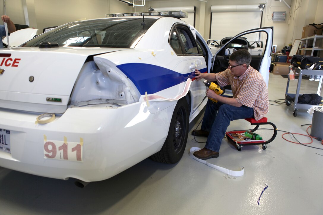 An employee of the Maintenance Support Division aboard Marine Corps Base Camp Lejeune adds decals to a new police car, Jan. 7. The Maintenance Support Division is among the G-6’s highest risk segments. G-6, which manages communications, lost only one day to mishaps, reducing their work time lost by 97.8 percent since last year.