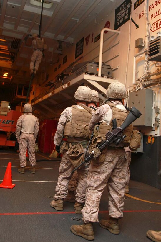 Marines with 81MM Mortar/Tactical Recovery of Aircraft and Personnel Platoon, Weapons Company, Battalion Landing Team 3/5, 15th Marine Expeditionary Unit, fast rope from the "hell hole" ian opening large enough for a Marine with gear to pass through, in USS Peleliu's hangar bay Dec. 30.  The 15th MEU is deployed as part of the Peleliu Amphibious Ready Group as a U.S. Central Command theater reserve force, providing support for maritime security operations and theater security cooperation efforts in the U.S. 5th Fleet area of responsibility. (U.S. Marine Corps photo by Cpl. John Robbart III)