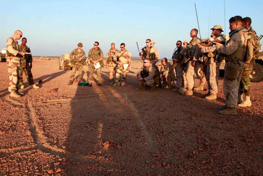 Marines with 2nd Platoon, Kilo Company, Battalion Landing Team 3/5, 15th Marine Expeditionary Unit, soldiers with the French 5th Marine Regiment and Djiboutian Army Cadets conduct a brief around a terrain model, during Exercise Amitie, in Djibouti, Dec. 9. Exercise Amitie, which is French for friendship exercise, is a multinational training exercise designed to increase interoperability, enhance mutual capabilities and support a sustained presence in the region. During Amitie, elements from the 15th MEU participated in a three-day mounted patrol, land and water obstacle courses, aviation-related evolutions and joint planning. The training was led by the French 5th Marine Regiment and included elements from the 15th Marine Expeditionary Unit, French Foreign Legion, U.S. Army, U.S. Air Force and Djiboutian military. The 15th MEU is deployed as part of the Peleliu Amphibious Ready Group as a U.S. Central Command theater reserve force, providing support for maritime security operations and theater security cooperation efforts in the U.S. 5th Fleet area of responsibility. (U.S. Marine Corps photo by Cpl. John Robbart III)