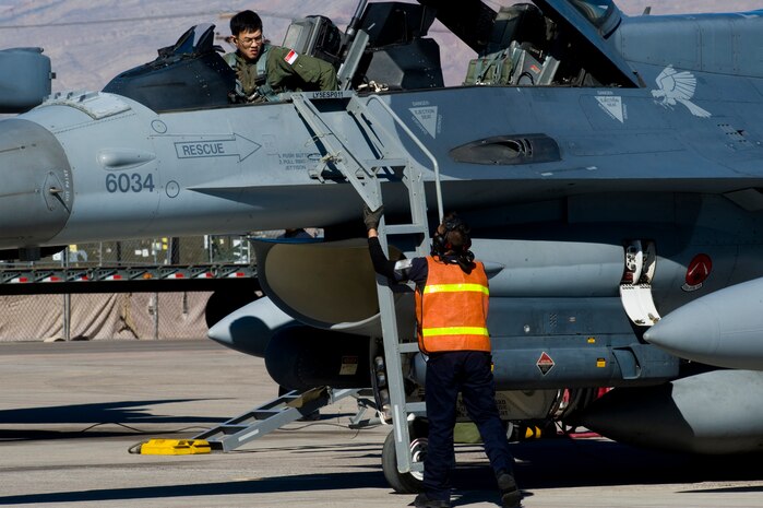 Airmen from the Republic of Singapore Air Force prepare an F-16 Fighting Falcon during RED FLAG 13-2 Jan. 21, 2013, at Nellis Air Force Base, Nev. RED FLAG, a realistic combat training exercise involving the air forces of the United States and its allies, is coordinated at Nellis Air Force Base, Nev., and conducted on the vast bombing and gunnery ranges of the Nevada Test and Training Range. Mock battles over the Nevada Test and Training Range yields results that will increase the combat capability of our armed forces for any future combat situation. (U.S. Air Force photo by Staff Sgt. William P. Coleman)