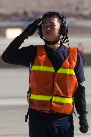 An Airman from the Republic of Singapore Air Force assigned to the 425th Fighter Squadron, Luke Air Force Base, Ariz., salutes an F-16 Fighting Falcon pilot as he taxis toward the runway during RED FLAG 13-2 Jan. 21, 2013, at Nellis Air Force Base, Nev. Each Red Flag exercise normally involves a variety of interdiction, attack, air superiority, defense suppression, airlift, air refueling and reconnaissance aircraft. (U.S. Air Force photo by Staff Sgt. William P. Coleman)  