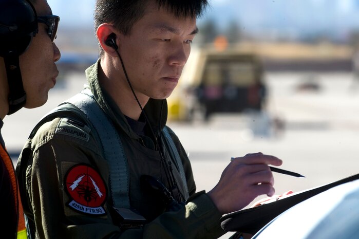Republic of Singapore Air Force Airmen assigned to the 425th Fighter Squadron at Luke Air Force Base, Ariz., read a pre-flight checklist during RED FLAG 13-2 Jan. 21, 2013, at Nellis Air Force Base, Nev. The squadron's current mission is to provide advanced weapons and tactics continuation training for Republic of Singapore Air Force F-16 Fighting Falcon pilots and maintenance personnel. (U.S. Air Force photo by Staff Sgt. William P. Coleman)