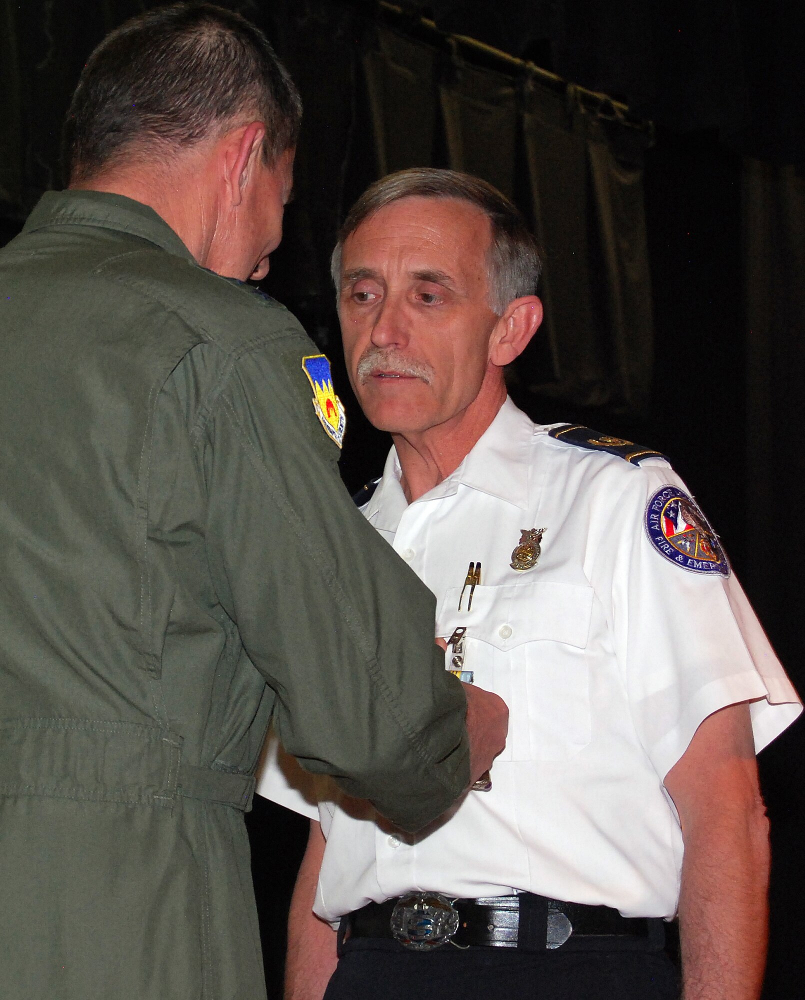 Air Force Academy Fire Chief Piercy Ernst receives an Air Force Meritorious Civilian Service Award medal from Lt. Gen. Mike Gould during a special presentation at a 10th Air Base Wing commander's call Jan. 18, 2013. Ernst worked at the Academy for 25 years, overseeing a unit that was, in 2001, the first in the Air Force to receive accreditation from the Commission on Fire Accreditation International. (U.S. Air Force photo/Don Branum)