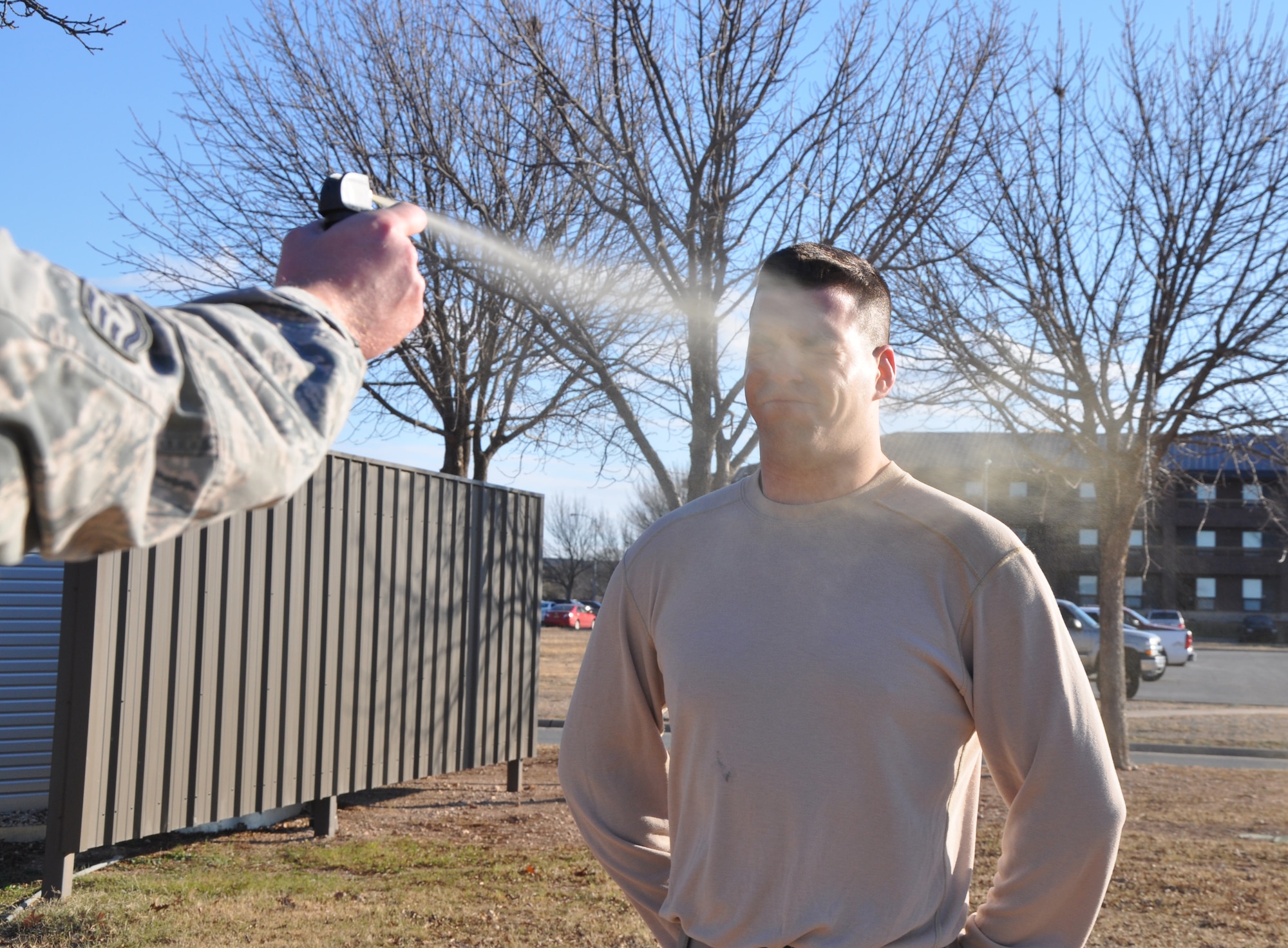 GOODFELLOW AIR FORCE BASE, Texas--  A Security Forces Squadron member is sprayed with OC, Jan. 15, outside the SFS building. SFS members must experience the effects of OC first hand before they can qualify to carry it. (U.S. Air Force photo/Airman 1st Class Jessica Keith) 