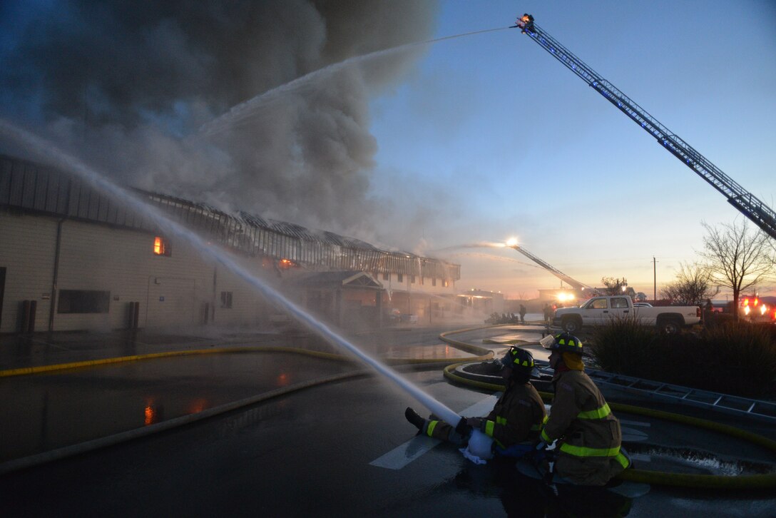 Firefighters work to extinguish a blaze at the Civil Engineer Squadron building Jan. 21, 2013, at Beale Air Force Base, Calif. (U.S. Air Force photo by Airman 1st Class Drew Buchanan/Released)