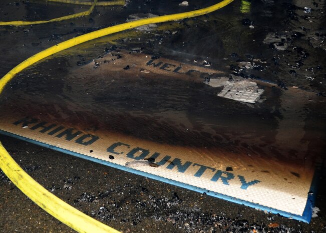 A welcome mat at the entrance to the 9th Civil Engineer Squadron entrance is flooded by water stained with soot during a fire at Beale Air Force Base, Calif., Jan. 21, 2013. The fire at the 9th CES building was suppressed by a unified response from Beale Airmen and local emergency response crews from the surrounding community. (U.S. Air Force photo by Senior Airman Shawn Nickel/Released)