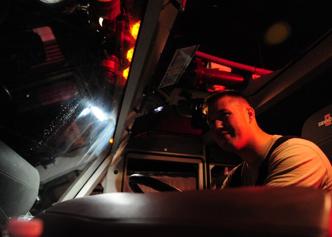 A firefighter from the 9th Civil Engineer Squadron controls a remote control water cannon from a fire truck at Beale Air Force Base, Calif., Jan. 21, 2013. A large structure fire started at approximately 2:30 p.m., and firefighters from Beale and the surrounding community fought the fire throughout the night. (U.S. Air Force photo by Senior Airman Shawn Nickel/Released)