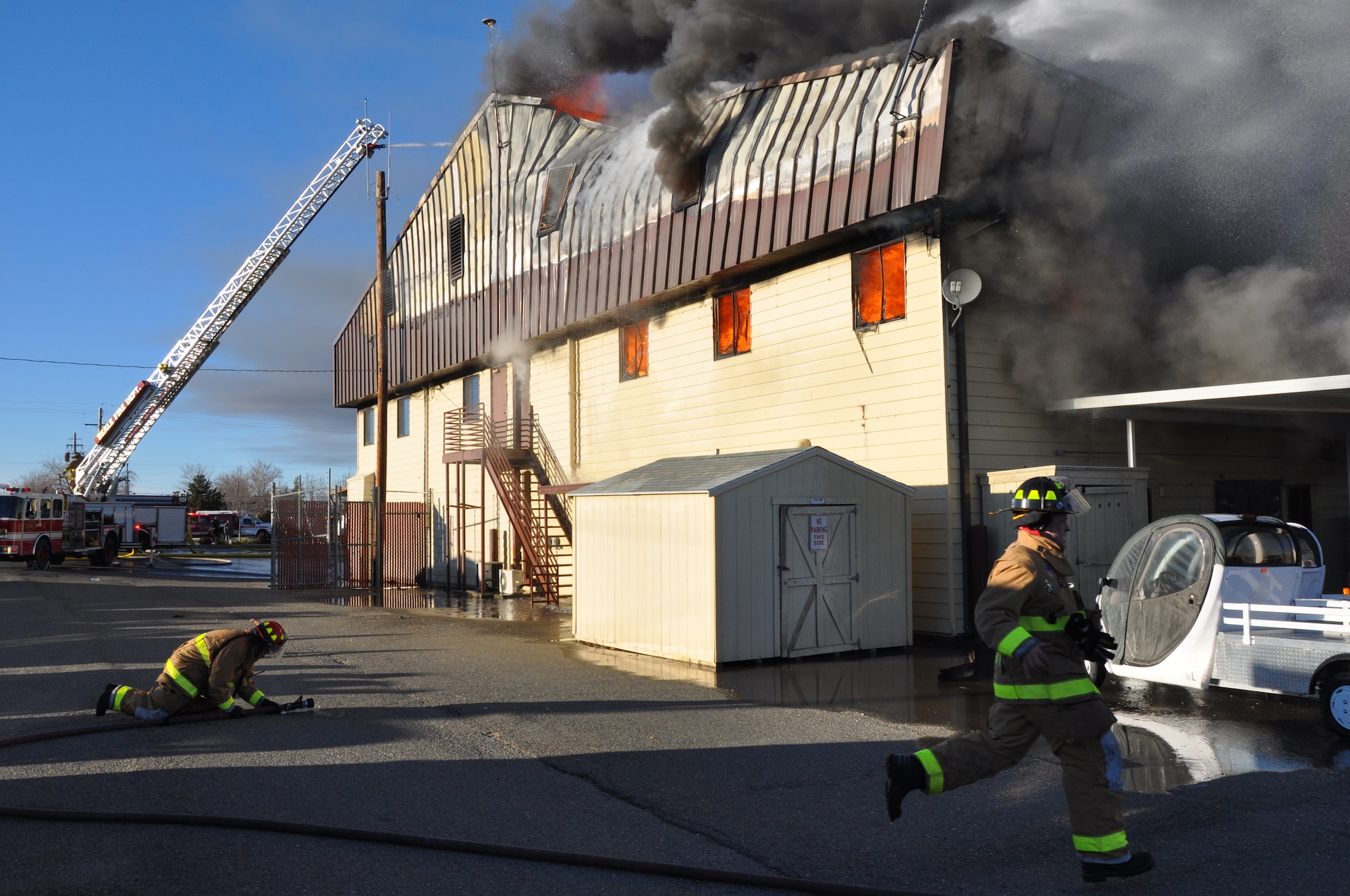 Firefighters move rapidly to extinguish flames at the 9th Civil Engineer Squadron building on Beale Air Force Base, Calif., Jan. 21, 2013. Beale firefighters teamed with multiple fire departments from the surrounding area to extinguish the fire. (U.S. Air Force photo by Airman 1st Class Bobby Cummings/Released)