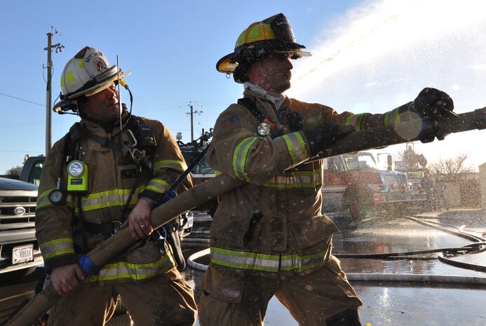 Local firefighters operate a hose to extinguish a fire at the 9th Civil Engineer Squadron building on Beale Air Force Base, Calif., Jan. 21, 2013.  Beale firefighters teamed with multiple fire departments from the surrounding area to extinguish the fire. (U.S. Air Force photo by Airman 1st Class Bobby Cummings/Released)