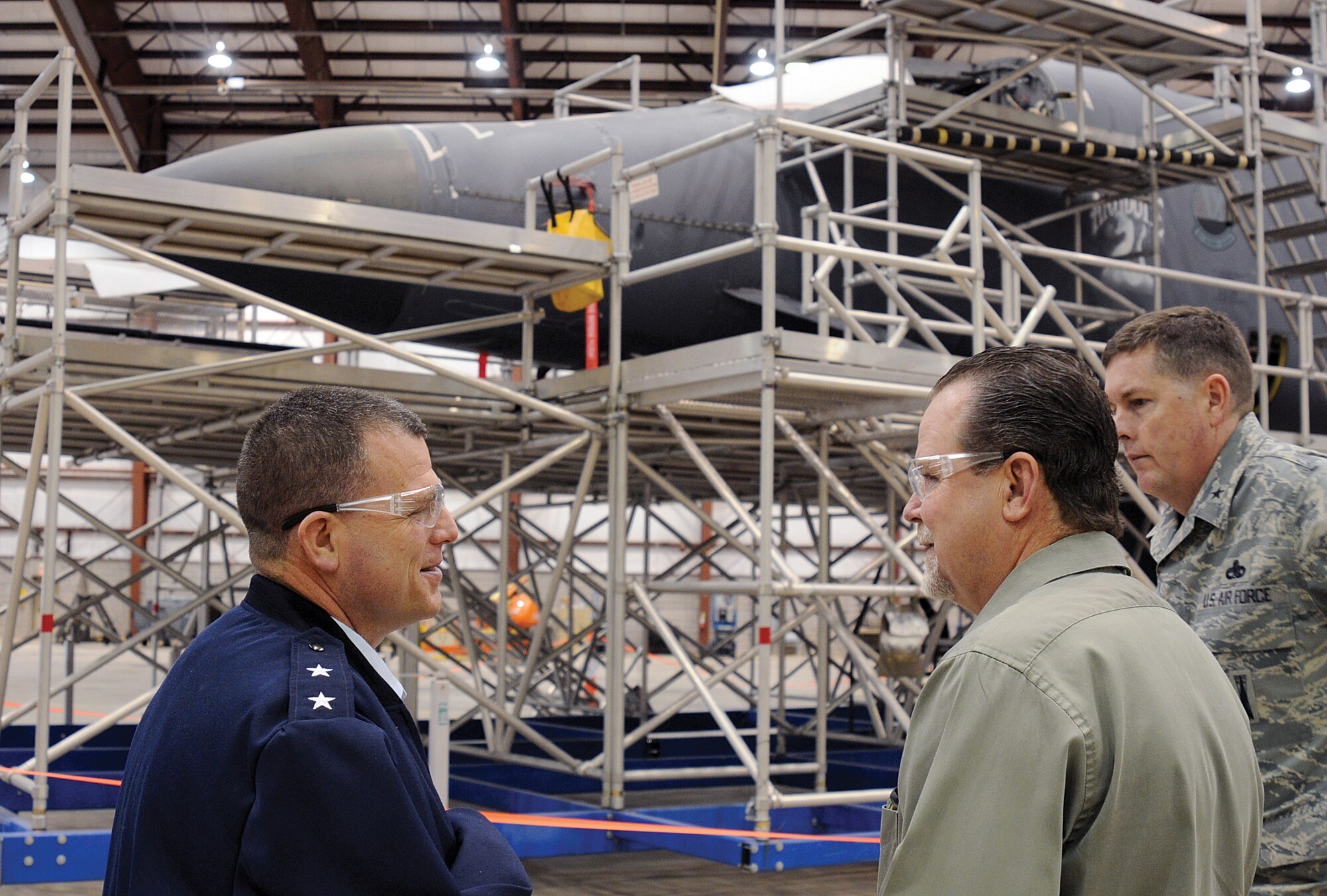 Maj. Gen. Dwyer Dennis, left, Program Executive Officer for Fighters and Bombers, Air Force Life Cycle Management Center at AFMC, Wright-Patterson Air Force Base, Ohio, discusses the B-1 Bomber Integrated Battle Station, IBS, modification under way on the jet nearby during his Jan. 10 visit to Tinker. The general was given a plane-side update in the Maintenance, Repair and Overhaul Technology Center hangar by Chuck Alley, Tinker’s 564th Aircraft Maintenance Squadron, among others.  General Dennis’s Jan. 10 visit to Tinker included a town hall meeting with all bomber system program office personnel. (Air Force photo by Margo Wright)