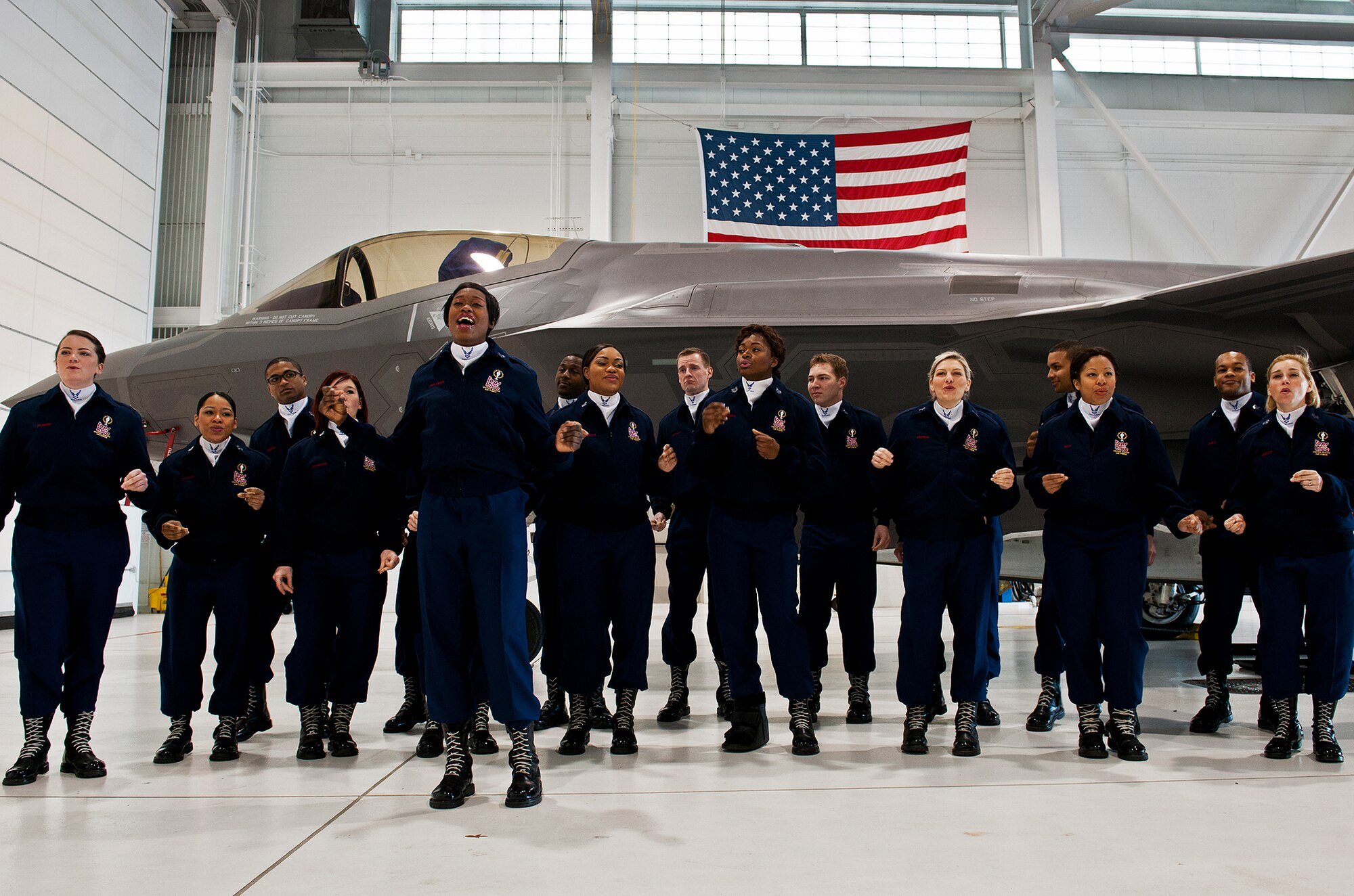 Senior Airman Brandi Skillman, a singer with the Air Force Tops in Blue, belts out a song for members of the 33rd Fighter Wing Jan. 22 at Eglin Air Force Base, Fla.  The group got an up-close view of an F-35A Lightning II while visiting the shop of one of their own, Tech. Sgt. Michael Menges, a member of the wing who's now a lighting and sound technician for TIB.  This was a short stop before their performance at the Emerald Coast Conference Center in Fort Walton Beach, Fla.  (U.S. Air Force photo/Samuel King Jr.)