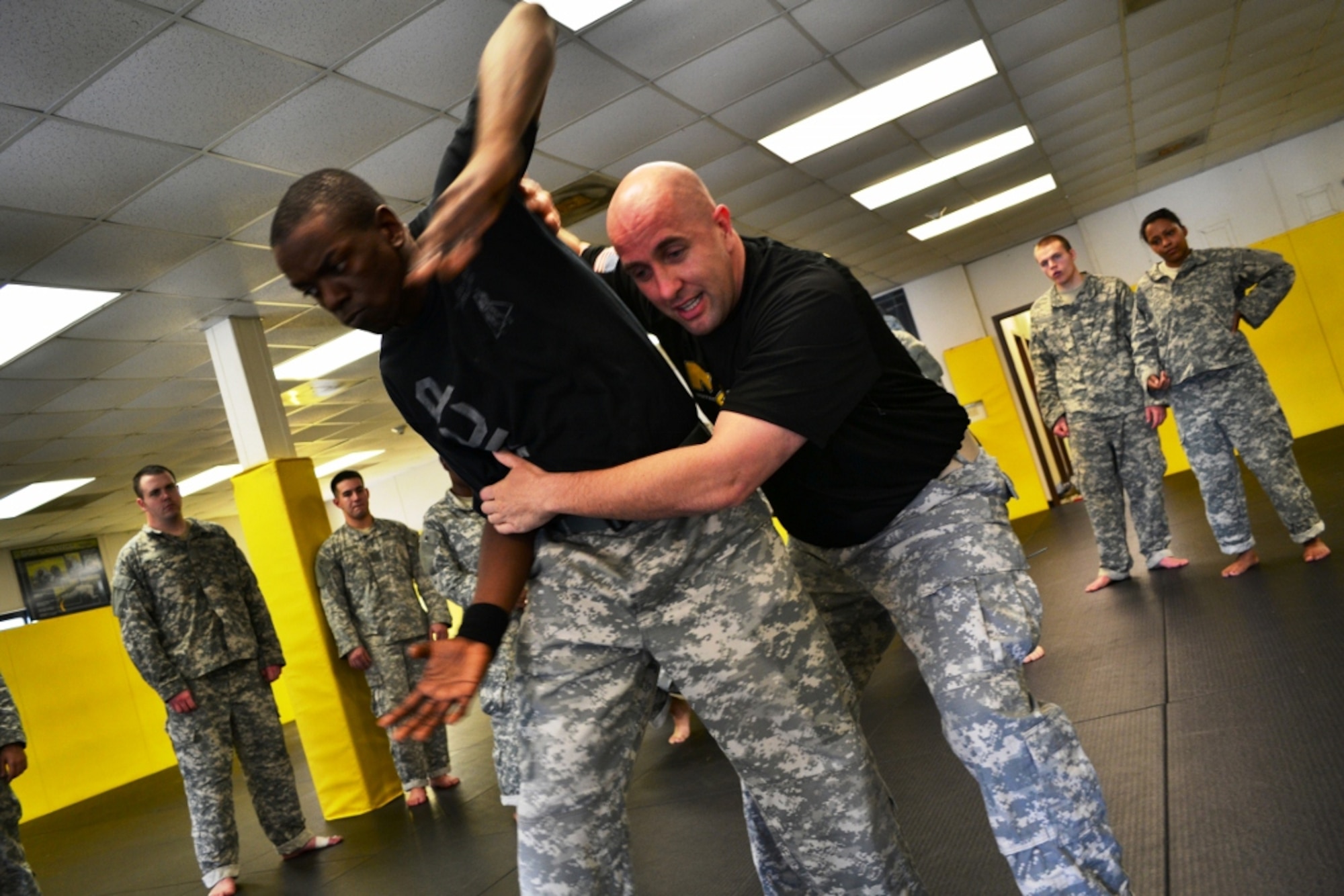 U.S. Army Staff Sgt. David Scott (right), the lead combatives instructor assigned to the Headquarters and Headquarters Company, 128th Aviation Brigade, applies a rear clinch to assistant instructor Spc. Kendrick Scott during day three of the 40-hour Modern Combatives Program at the Fort Eustis Combatives Academy at Fort Eustis, Va., Jan 9, 2012. Scott said, “Army combatives maintains the warrior ethos. It instills the will to fight and engage the enemy,” and allows Soldiers to “finish the fight” should they become disarmed. (U.S. Army photo by Sgt. Edwin Rodriguez/Released)