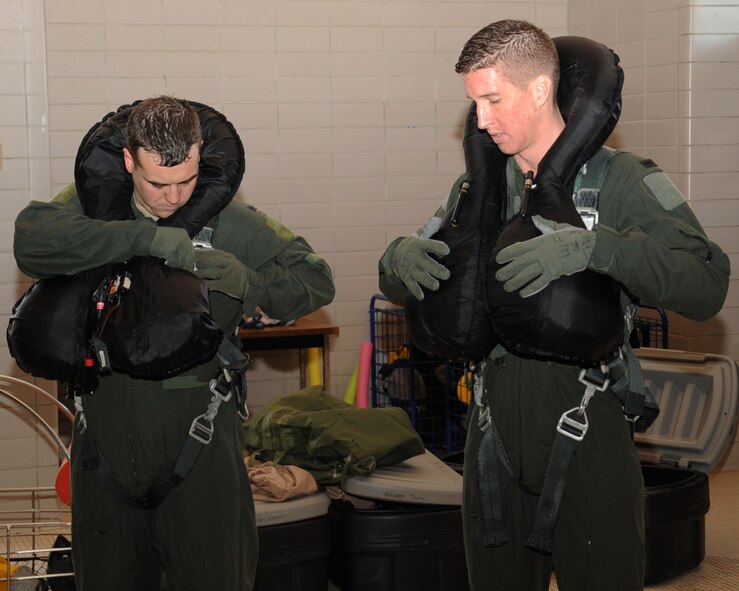 1st Lt. Jarrad Thorley, 20th Bomb Squadron navigator, and Andrew Greenhill, 20 BS electronic warfare officer, adjust their life vests during Survival, Evasion, Resistance and Escape water survival training at Louisiana State University Shreveport Natatorium, Shreveport, La., Jan. 22. The training familiarized aircrew with their equipment and how to properly use it in the event of a crash. (U.S. Air Force photo/Senior Airman Sean Martin)
