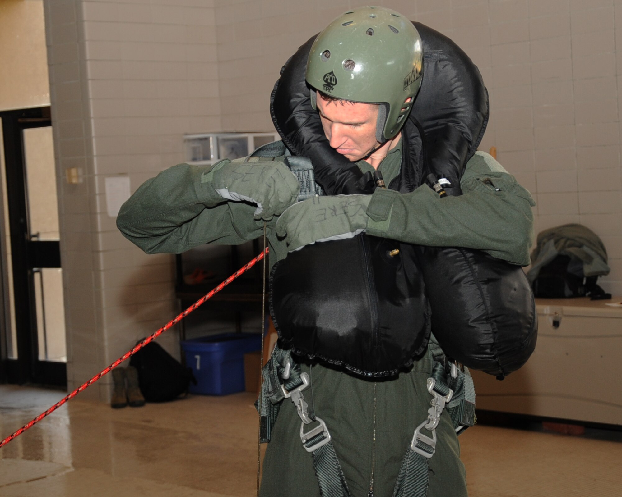 1st Lt. Jarrad Thorley, 20th Bomb Squadron navigator, attaches a harness during Survival, Evasion, Resistance and Escape water survival training at Louisiana State University Shreveport Natatorium, Shreveport, La., Jan. 22. The training consisted of basic water survival techniques and the certification is valid for three years. (U.S. Air Force photo/Senior Airman Sean Martin)