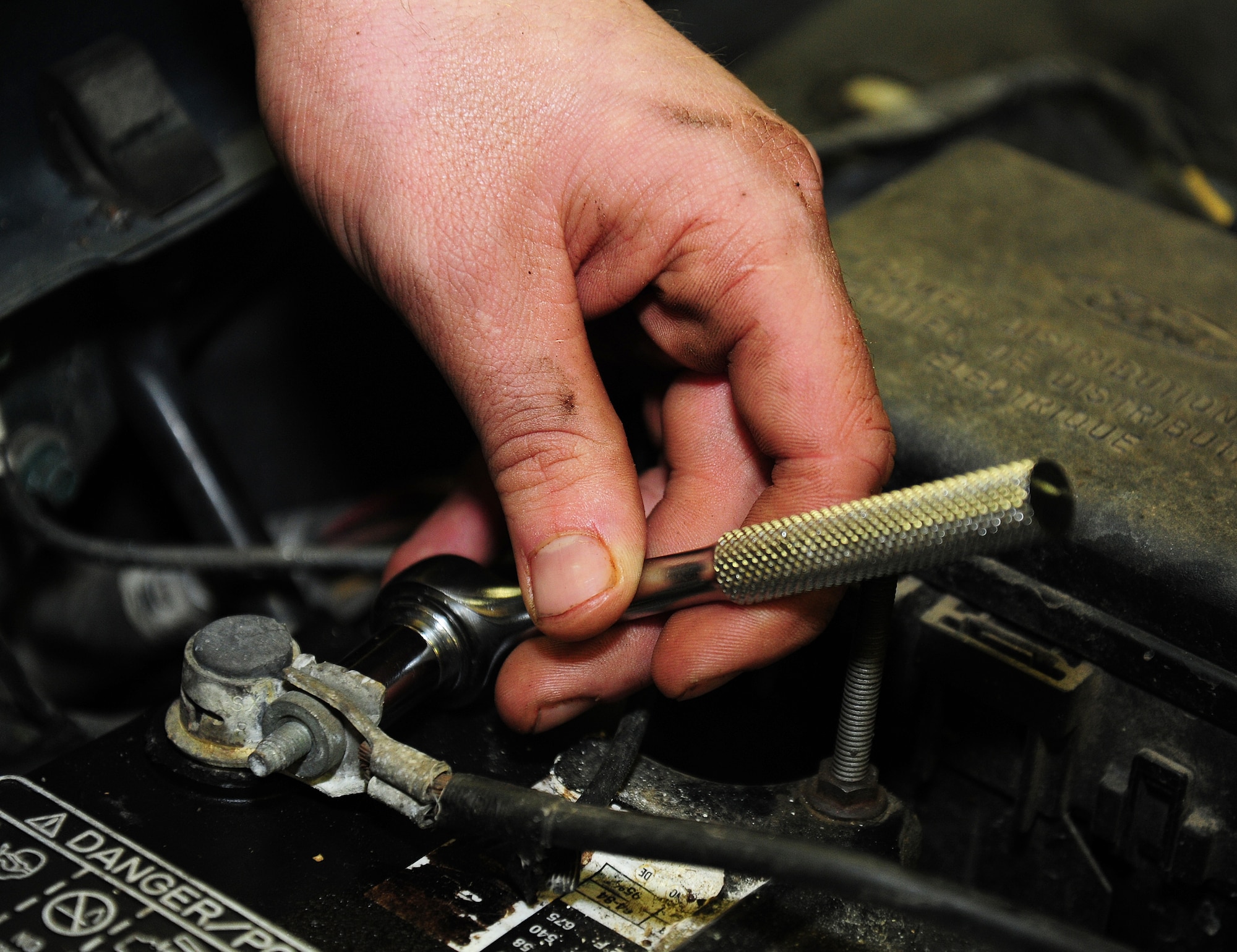 Airman 1st Class Thomas Steinke, 66th Training Squadron survival, evasion, resistance and escape student, tightens the screws on his car battery at the auto hobby shop at Fairchild Air Force Base, Wash., Jan. 18, 2013. Steinke chose to use the auto hobby shop because of the affordable price to rent the bay as well as the convenience of being on base. (U.S. Air Force photo by Airman 1st Class Janelle Patiño)