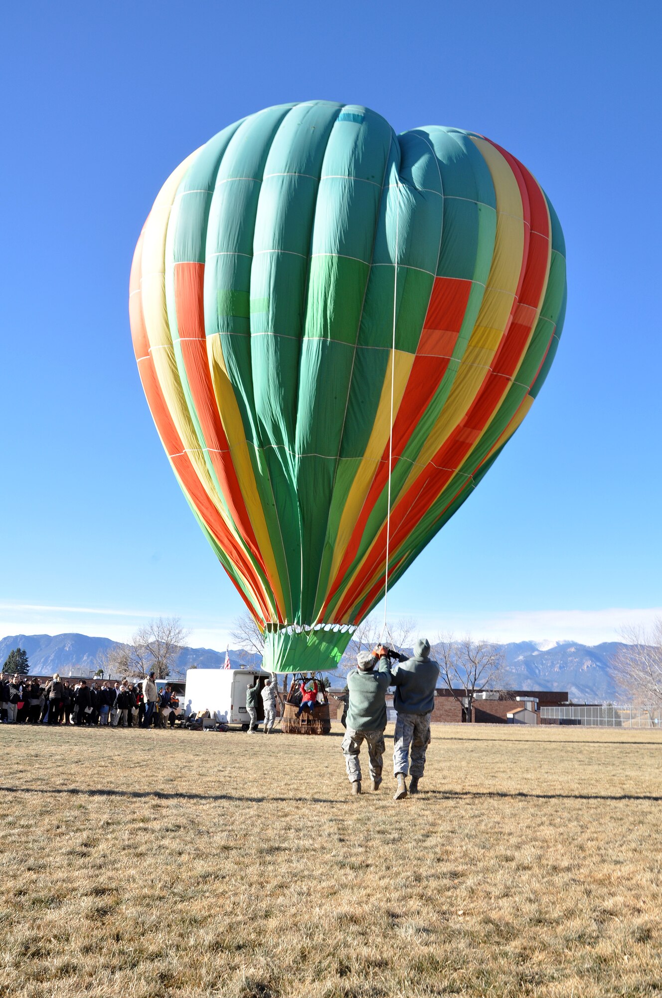 Staff Sgt. Caleb Scott, left, and Staff Sgt. Damarcus Forney, 721st Communications Squadron project managers, cling to a rope as they steady the balloon amidst 20 mph wind gusts Dec. 17, 2012, at Swigert Academy. As a STEAM school, Swigert Academy emphasizes the importance of math and science to its students while preparing them for the future through an academically challenging environment while fostering creativity and teamwork. (U.S. Air Force photo/Staff Sgt. J. Aaron Breeden)