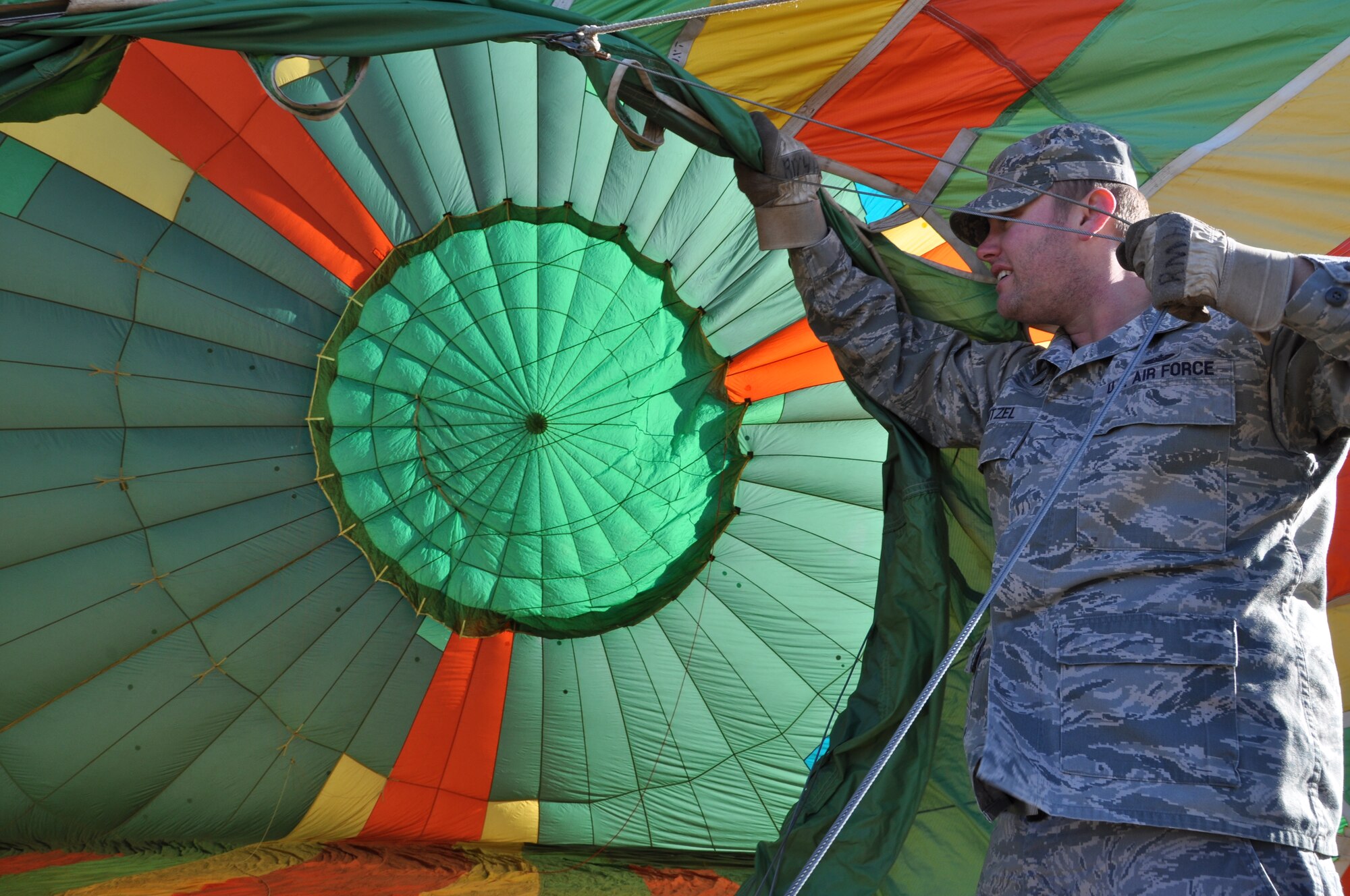 Staff Sgt. Aaron Leitzel, 614th Air and Space Communications Squadron satellite communication manager, helps hold the opening of the balloon while being inflated Dec. 17, 2012, at Swigert Academy. As a STEAM school, Swigert Academy emphasizes the importance of math and science to its students while preparing them for the future through an academically challenging environment while fostering creativity and teamwork. (U.S. Air Force photo/Staff Sgt. J. Aaron Breeden)