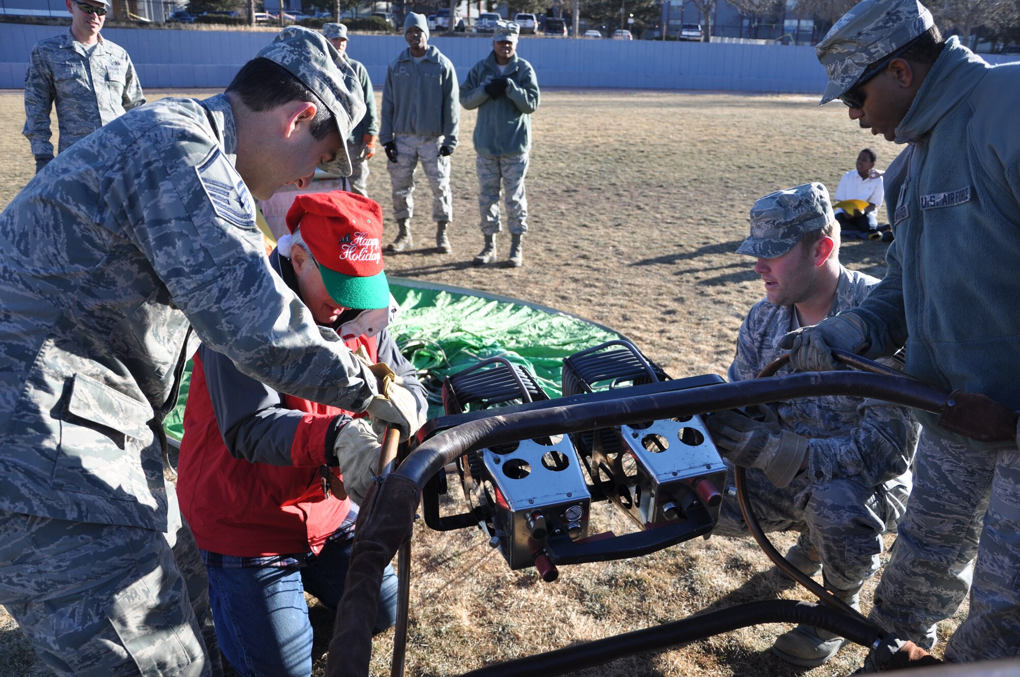 Stephen Blucher, hot air balloonist, is assisted by Airmen from Peterson Air Force Base, Colo., to connect the balloon’s ignition system to the frame of the basket Dec. 17, 2012, at Swigert Academy. As a STEAM school, Swigert Academy emphasizes the importance of math and science to its students while preparing them for the future through an academically challenging environment while fostering creativity and teamwork. (U.S. Air Force photo/Staff Sgt. J. Aaron Breeden)