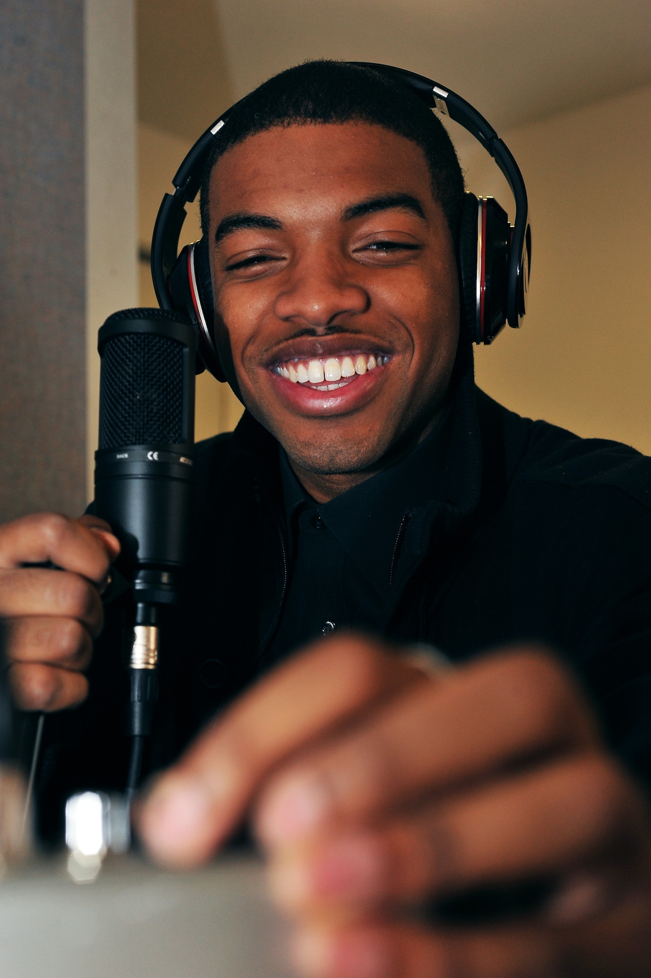 Airman 1st Class Dracy Green adjusts the microphone sound settings during a recording session on Ramstein Air Base, Germany, Jan. 15, 2013. Green sells his music from an online website that donates 20 percent of its proceeds to charities that support military members on base. (U.S Air Force photo/ Airman 1st Class Dymekre Allen)