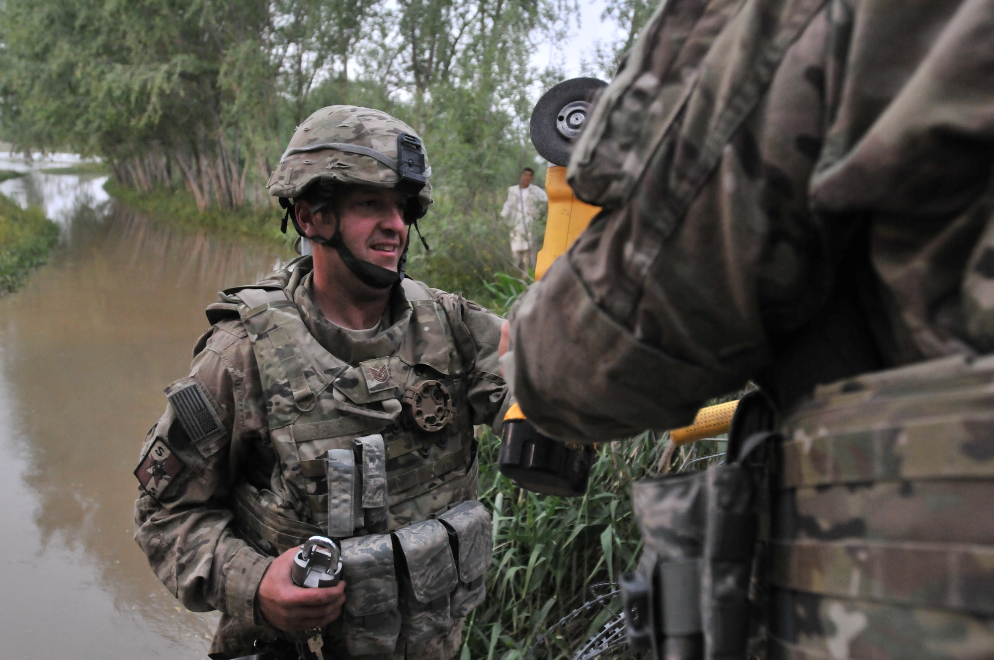 New York Air National Guard Tech. Sgt. Michael McQuown, a member of the 174th Attack Wing Security Forces Squadron, works to help secure drainage grates and razor wire on flooded fields outside Bagram Air Base, Afghanistan in late 2012. McQuown was one of 30 members of Hancock Field Air National Guard Base, Syracuse, New York who deployed to Afghanistan to provide an array of security functions. (Photo by New York Air National Guard Staff Sgt. Ronald Atwood/Released)