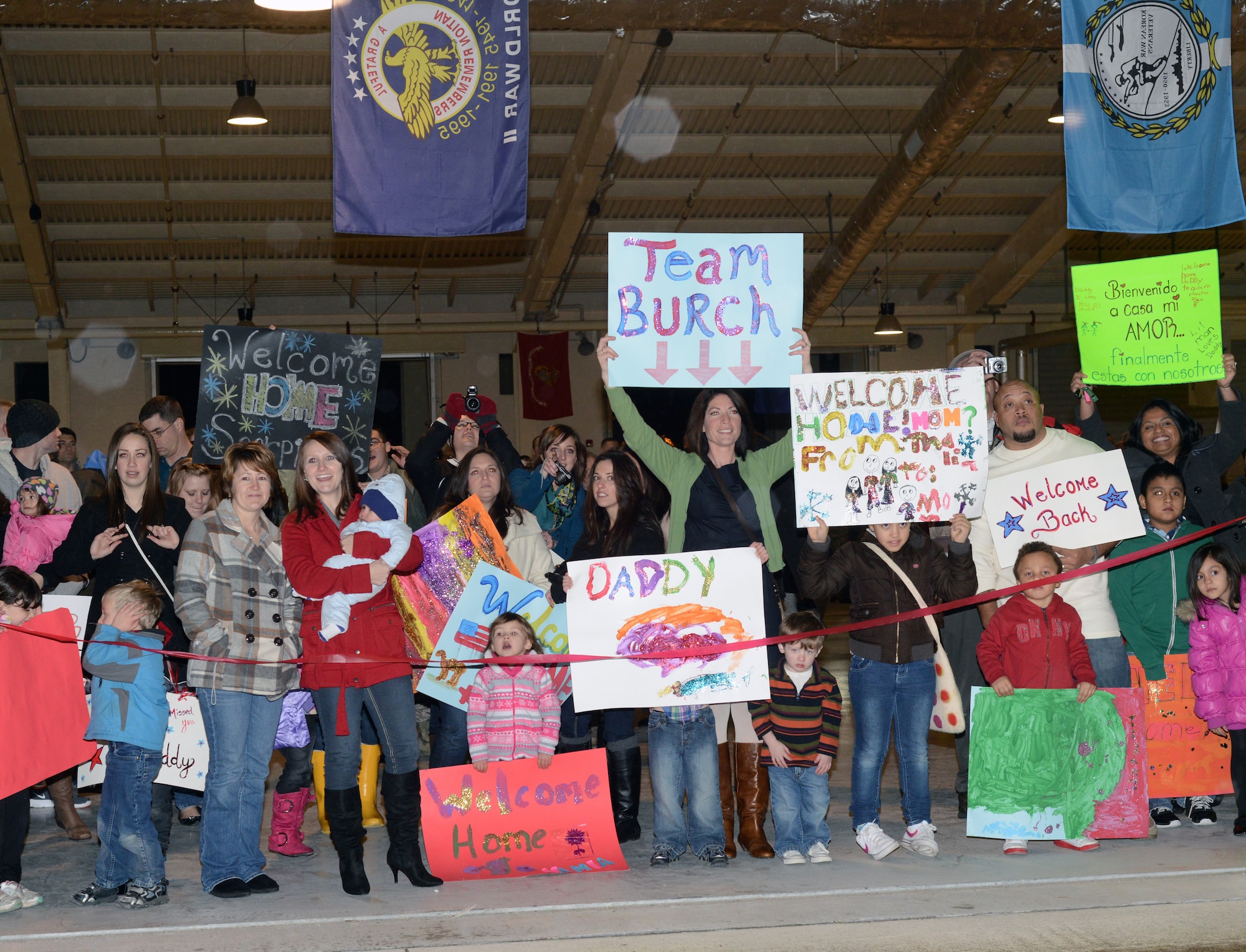 Family members await the return of the 603rd Air Control Squadron Jan. 19, 2013 at Aviano Air Base, Italy. The unit returned from their final deployment before the squadron is deactivated later this year. (U.S. Air Force photo/Senior Airman Michael Battles)