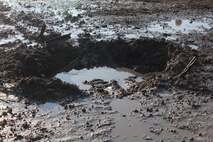 A crater left by an explosive detonated by Marines with Bridge Company, 8th Engineer Support Battalion, 2nd Marine Logistics Group fills with water at a range aboard Camp Lejeune, N.C., Jan. 18, 2013. The explosive ripped a hole through a line of barbed wire during the unit’s urban breaching and demolition training, which also prepared the Marines to use explosives to blow down doors and create holes in walls for urban assault teams. 
