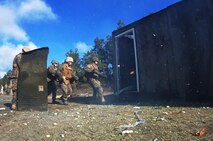 Marines with Bridge Company, 8th Engineer Support Battalion, 2nd Marine Logistics Group charges through a doorway after demolishing the entrance with explosives during the unit’s urban breaching and demolition training aboard Camp Lejeune, N.C., Jan. 18, 2013. The Marines also used high explosives to clear common battlefield obstacles such as barbed wire. 