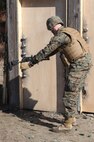 A Marine prepares to shoot around a lock during Bridge Company, 8th Engineer Support Battalion, 2nd Marine Logistics Group’s urban breaching and demolition training aboard Camp Lejeune, N.C., Jan. 18, 2013. The Marines fired slugs from the M-1014 Joint Service Combat Shotgun and detonated high explosives to breach doors in preparation for assault teams.