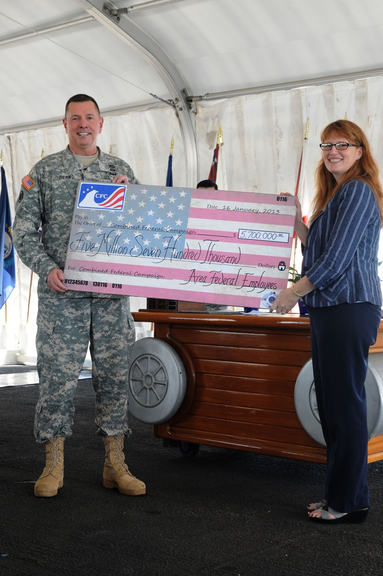Maj. Gen. William Beard, U.S. Army Pacific deputy commanding general, presents Ms. Colby Stanton, Federal Executive Board vice chair, an oversized check for $5,731,426.19 on behalf of the 27,298 donors within the Hawaii Pacific area at Ford Island, Hawaii, Jan. 16, 2013. Beard presented the check during a 2012 Hawaii-Pacific Combined Federal Campaign recognition ceremony held aboard the USS Missouri. (Courtesy photo)