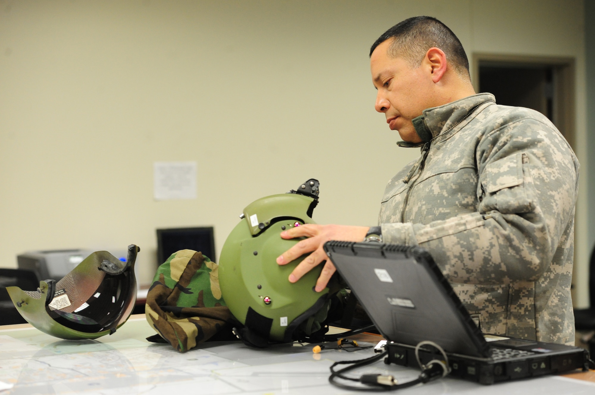 WHITEMAN AIR FORCE BASE, Mo. -- U.S. Army Chief Warrant Officer 4 Jim Nix, 1 -135th Attack Reconnaissance Battalion standardization instructor pilot, re-sizes his helmet for night vision goggle operations, Jan. 16. Pilots perform nighttime operations to prepare for future deployments and to meet training requirements. (U.S. Air Force photo/Staff Sgt. Nick Wilson) (Released)
