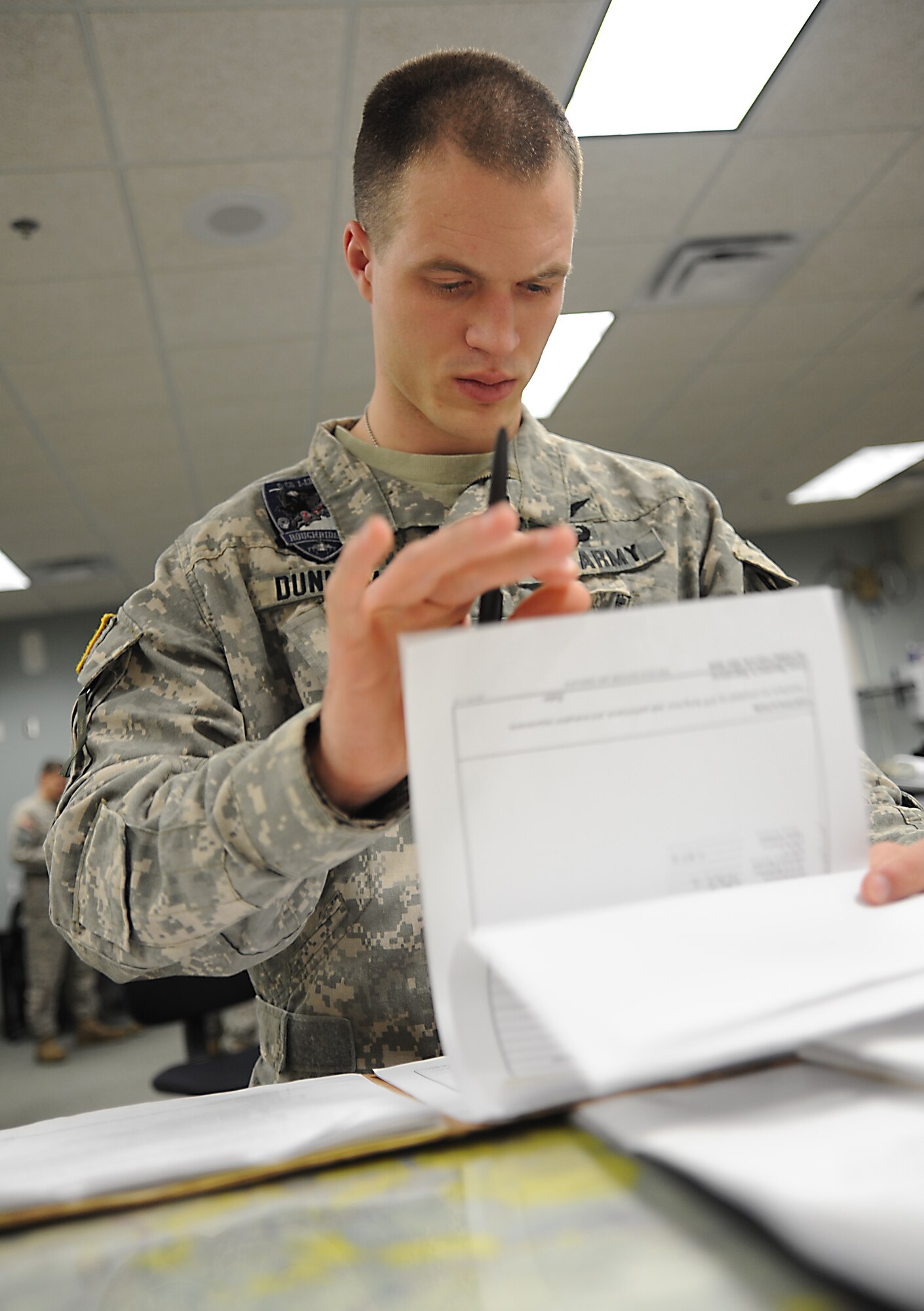 WHITEMAN AIR FORCE BASE, Mo. -- U.S. Army 1st Lt. Caleb Dunham, 1-135th Attack Reconnaissance Battalion platoon leader, reviews training records, Jan. 16. Training records helps pilots identify strengths and weaknesses so they can make improvements during future flights. (U.S. Air Force photo/Staff Sgt. Nick Wilson) (Released)