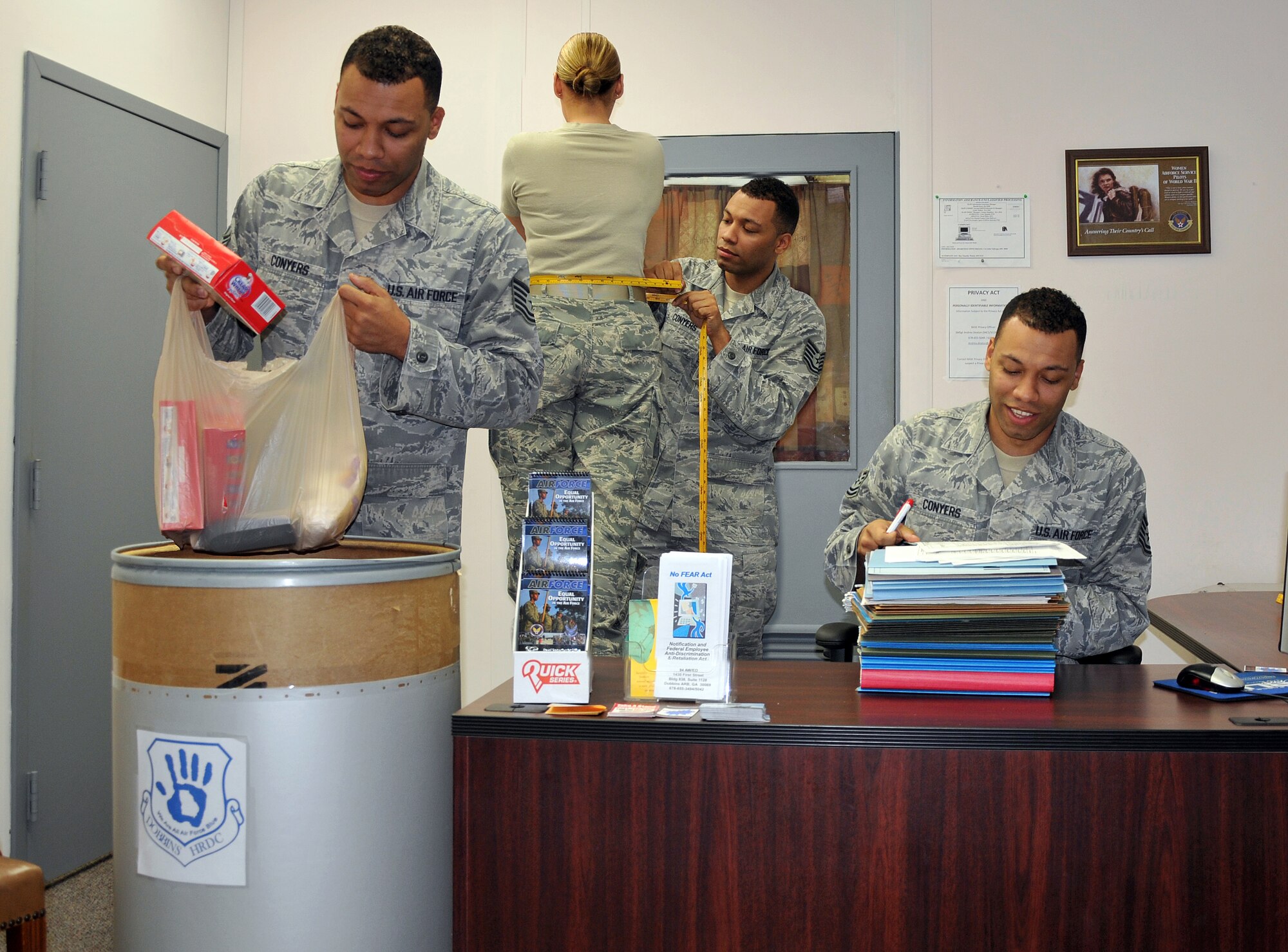 Tech. Sgt. Richard Conyers, 94th Equal Employment Office interim director, sorts food donated by Dobbins personnel for Airmen in need, measures an Airman and goes through EEO paperwork. Conyers and EEO specialists often need to multi-task to handle the multiple additional duties they have. (U.S. Air Force photo illustration/Senior Airman Elizabeth Van Patten)