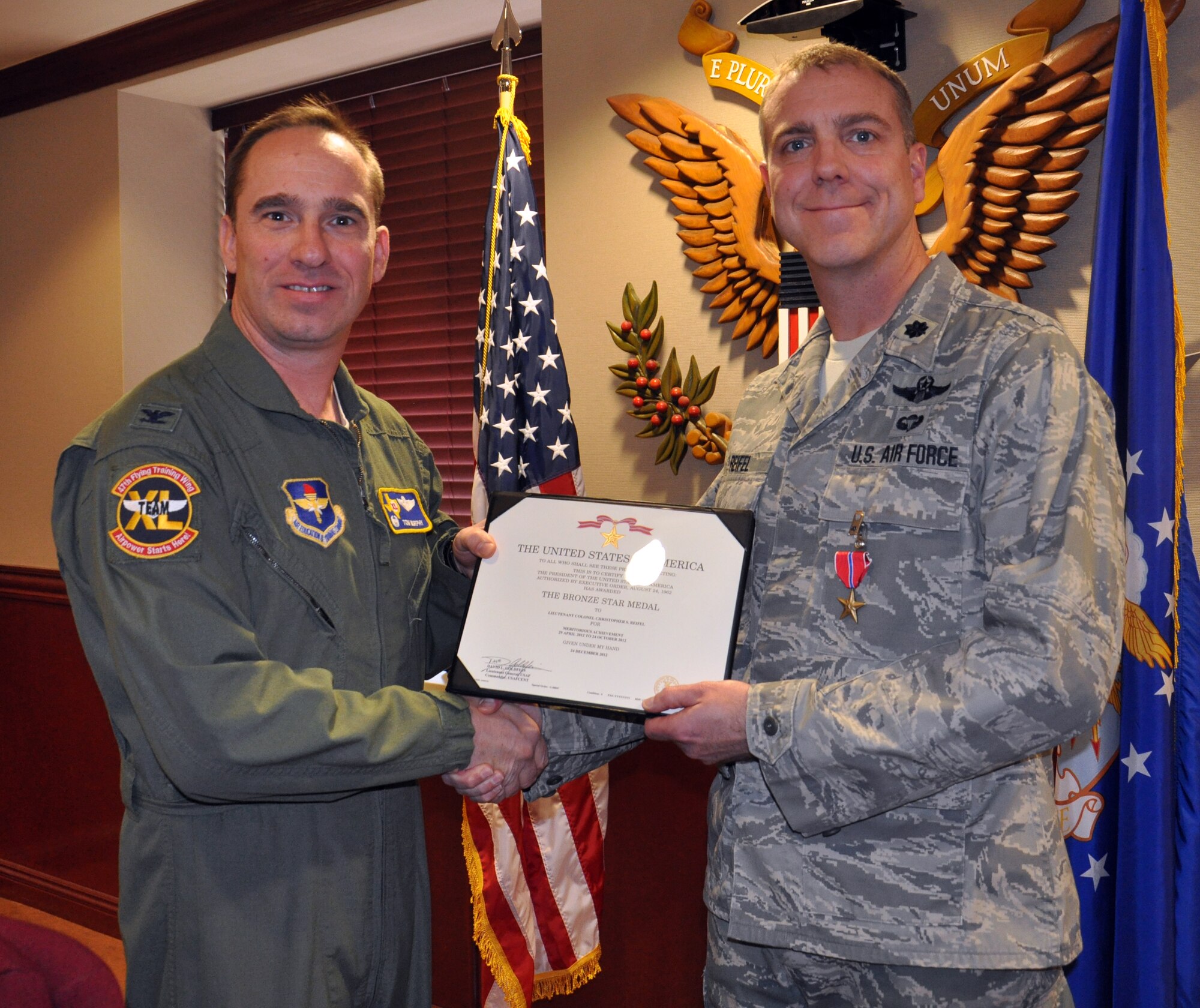 Lt. Col. Christopher Reifel, 47th Flying Training Wing director of wing plans and programs, poses for a photo with Col. Tom Murphy, 47th FTW commander, after being awarded the Bronze Star Medal during a ceremony in the wing conference room at Laughlin Air Force Base, Texas, Jan. 15, 2013. Reifel earned the Bronze Star during a deployment to Afghanistan for his leadership and commitment to his mission. (U.S. Air Force photo/2nd Lt. James Ramirez)