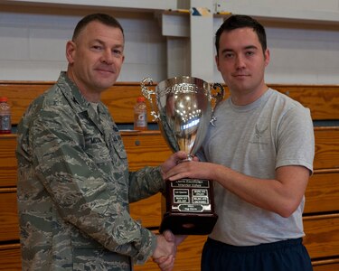 Col. Richard McComb, Joint Base Charleston commander, presents the Dorm Challenge trophy to Senior Airman Michael Jones, 437th Maintenance Squadron aircraft parts store journeyman, representing dorm 466, which won the Dorm Challenge Jan. 18, 2013, at Joint Base Charleston - Air Base, S.C. The quarterly Dorm Competition is a Wing initiative that is intended to encourage and incorporate all aspects of Comprehensive Airman Fitness, while also encouraging resident interaction and camaraderie. The Dorm Challenge consisted of push-ups, sit-ups and a game of dodgeball. (U.S. Air Force photo/Airman 1st Class Ashlee Galloway)