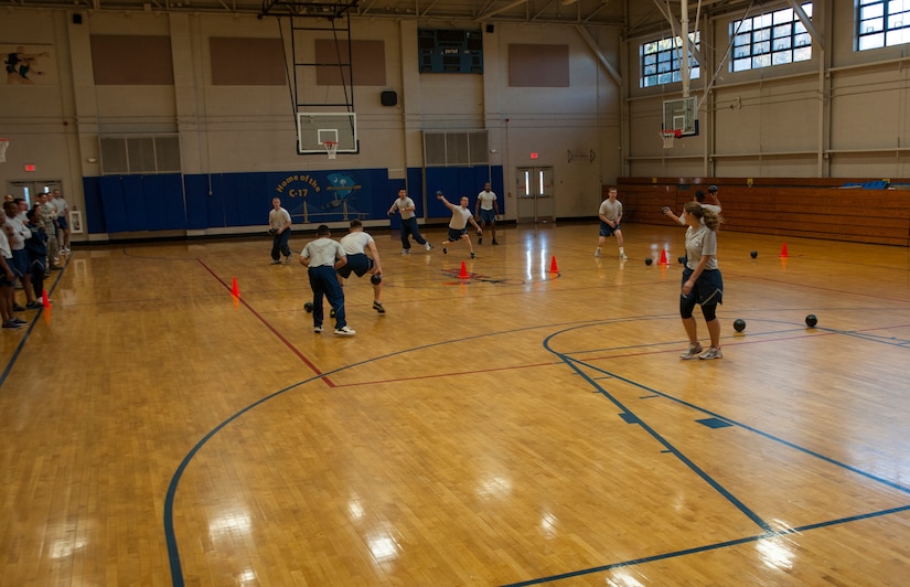 Airmen from the Joint Base Charleston dorms scramble to take out their opponents during the Dorm Challenge dodgeball game Jan. 18, 2013, at Joint Base Charleston - Air Base, S.C. The quarterly Dorm Competition is a Wing initiative that is intended to encourage and incorporate all aspects of Comprehensive Airman Fitness, while also encouraging resident interaction and camaraderie. The Dorm Challenge consisted of push-ups, sit-ups and a game of dodgeball. (U.S. Air Force photo/Airman 1st Class Ashlee Galloway)