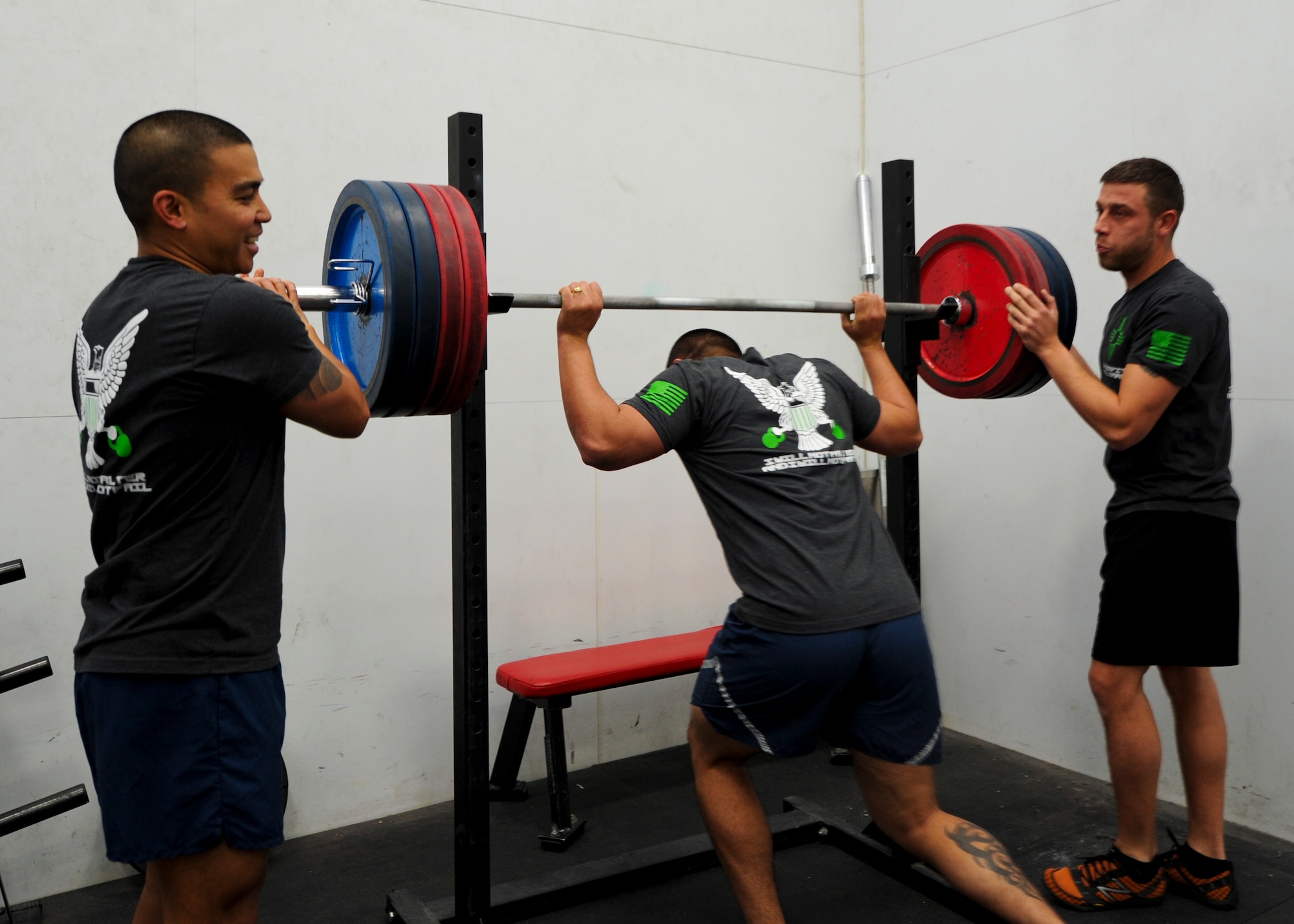 Two male athletes assist another in replacing the dead lift bar at the Domenici Fitness and Sports Center at Holloman Air Force Base, N.M., Jan. 23. The fitness center offers free classes and is open seven days per week. (U.S. Air Force photo by Staff Sgt. Carolyn Herrick/released)